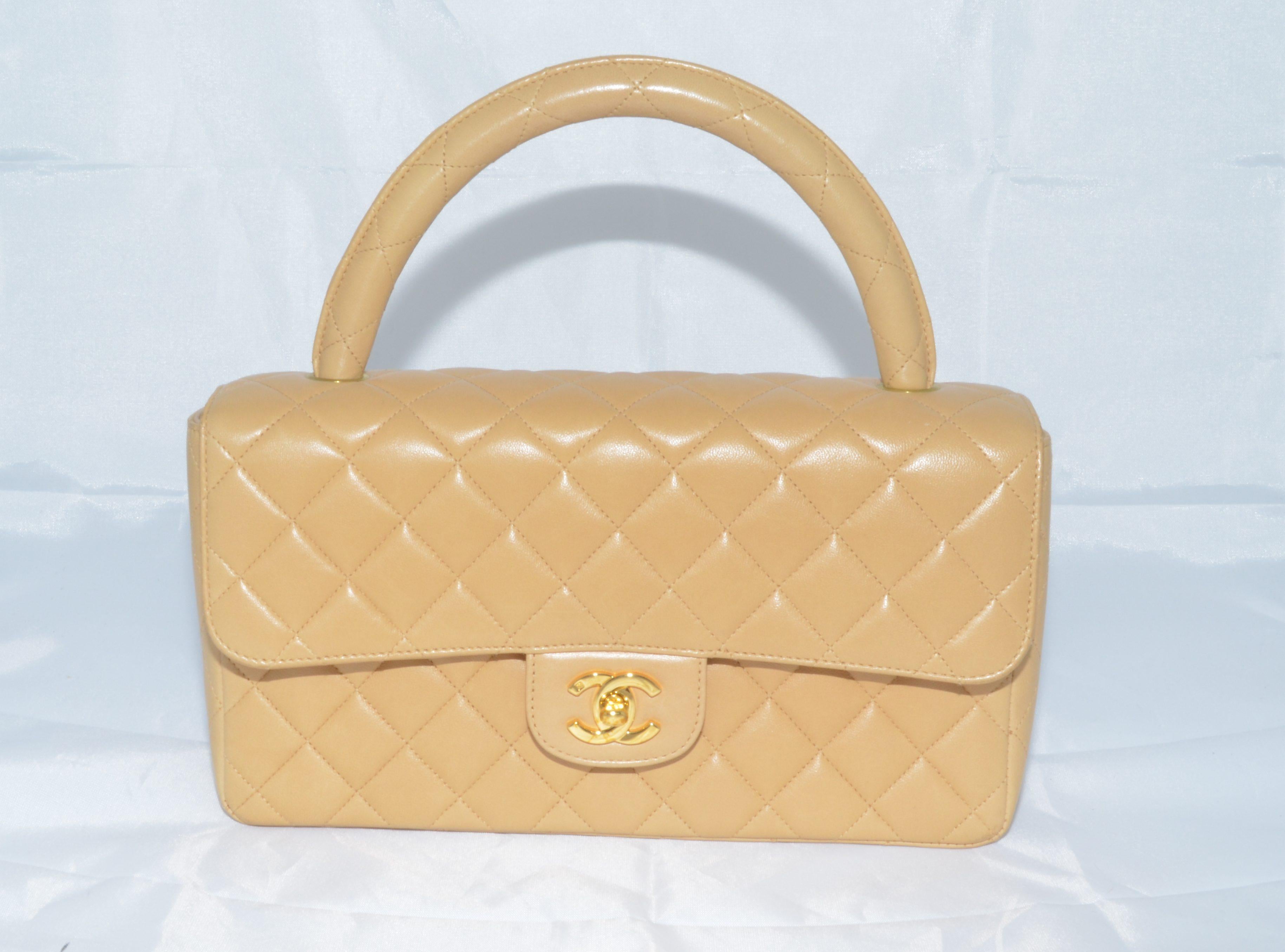 Vintage Chanel bag is featured in a beige-colored quilted leather with a single top handle, back slip pocket, and a signature CC turnlock closure in gold-plated hardware. Interior is fully lined in leather and offers one slip pocket and one zippered