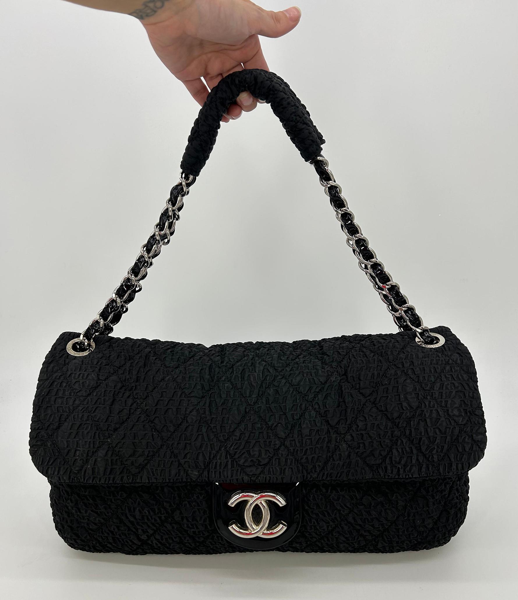 RARE Chanel Black Cloquèe XL Classic Flap  in good condition. Black textured nylon in quilted diamond pattern trimmed with silver hardware and black patent leather. Silver CC logo upon front magnetic snap closure which opens via single flap to a