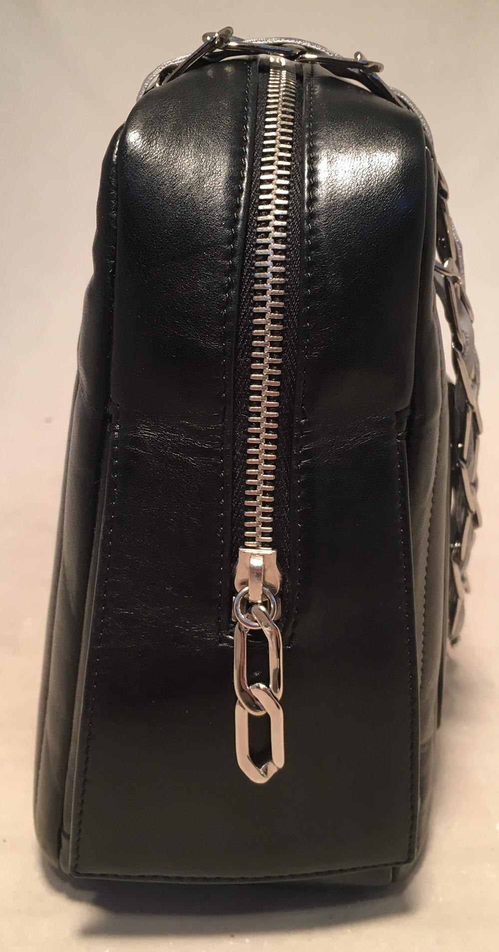 Chanel Mademoiselle Ligne Vertical Quilted Camera Bag in excellent condition. black vertical stripe quilted lambskin exterior trimmed with silver hardware and a unique woven chain and reflective ribbon shoulder strap that can be worn long or short.