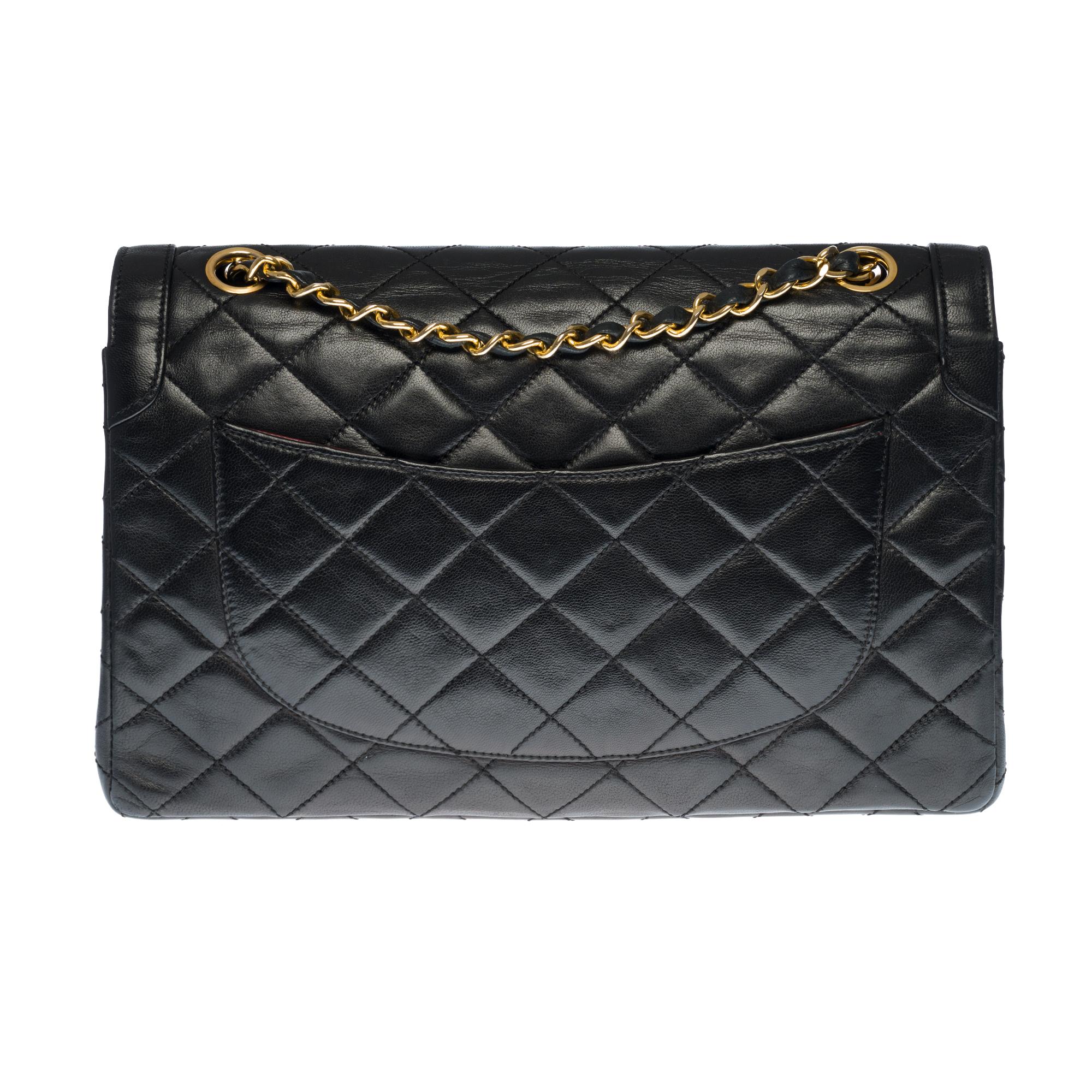 Beautiful Chanel Timeless/Classique handbag with double flap in black quilted leather, gold metal trim, a chain handle in gold metal intertwined with black leather allowing a hand or shoulder support.

Two-tone gold/silver metal flap closure..
Patch