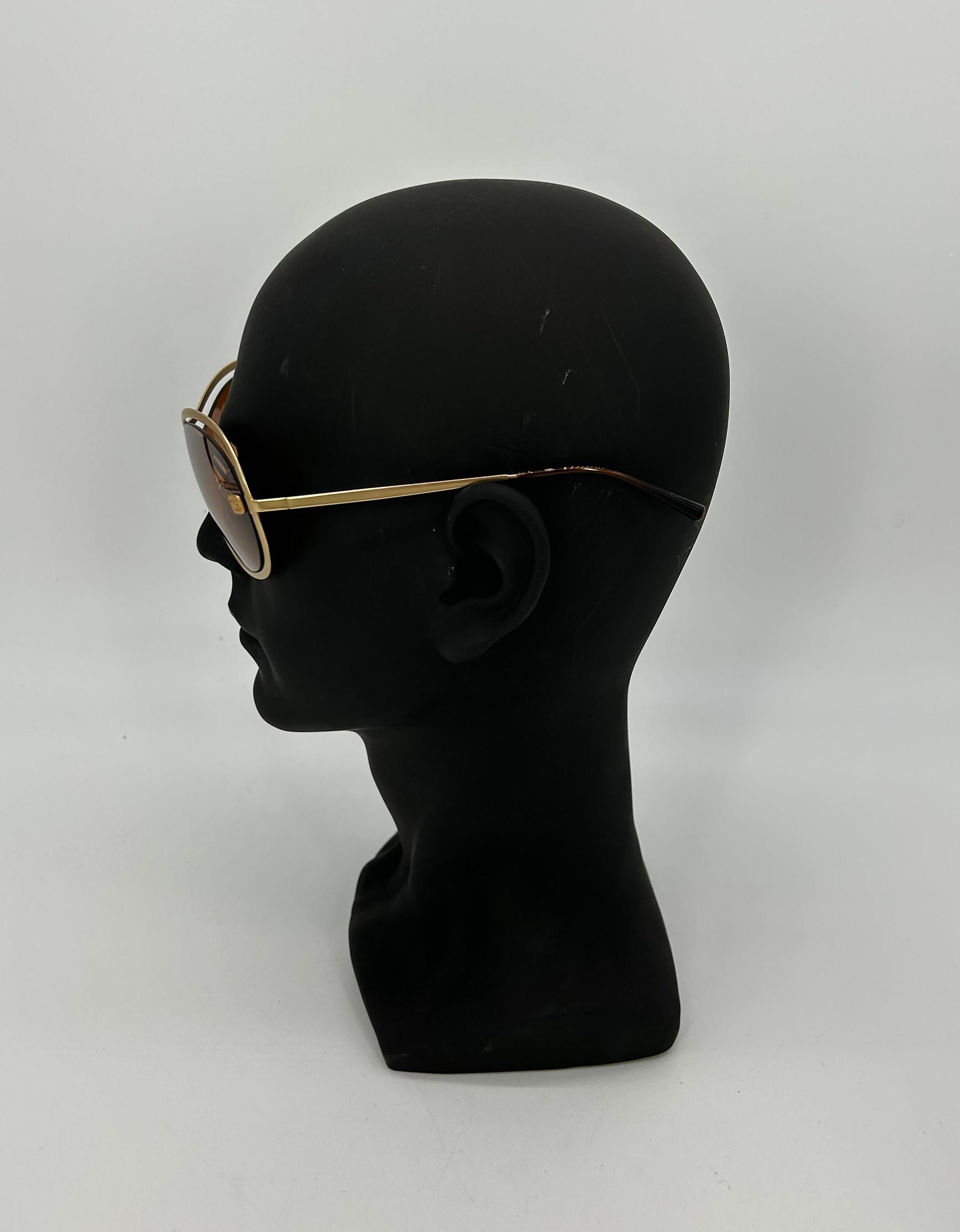 RARE Vintage Chanel Gold Floating Frame Tan Mirror Lens Sunglasses in very good condition c 2000s.  Matte gold hardware frame in unique floating design that appears to levitate around the lenses.  Chanel logo engraved on center bridge of lens. CC