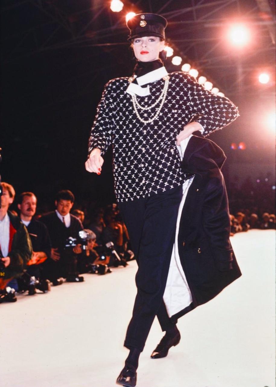 Rare collectible suit from Chanel Fall/Winter 1987 collection by Karl Lagerfeld. This classy boxy LBJ and a matching pencil skirt are made of black tweed boucle with white X cross pattern throughout and adorned with white pearl buttons. Very good