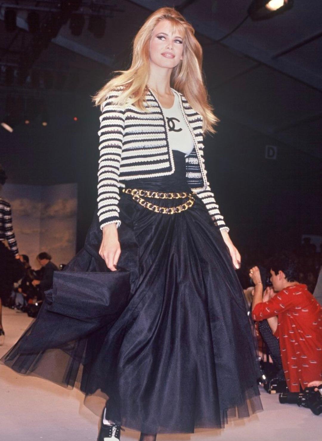 This is an exceptionally rare vintage Chanel skirt from the Spring 1992 collection, designed by Karl Lagerfeld. Crafted in delicate layers of black tulle, the skirt features a dramatic high-rise, corset-style waistline with exquisite ruching that
