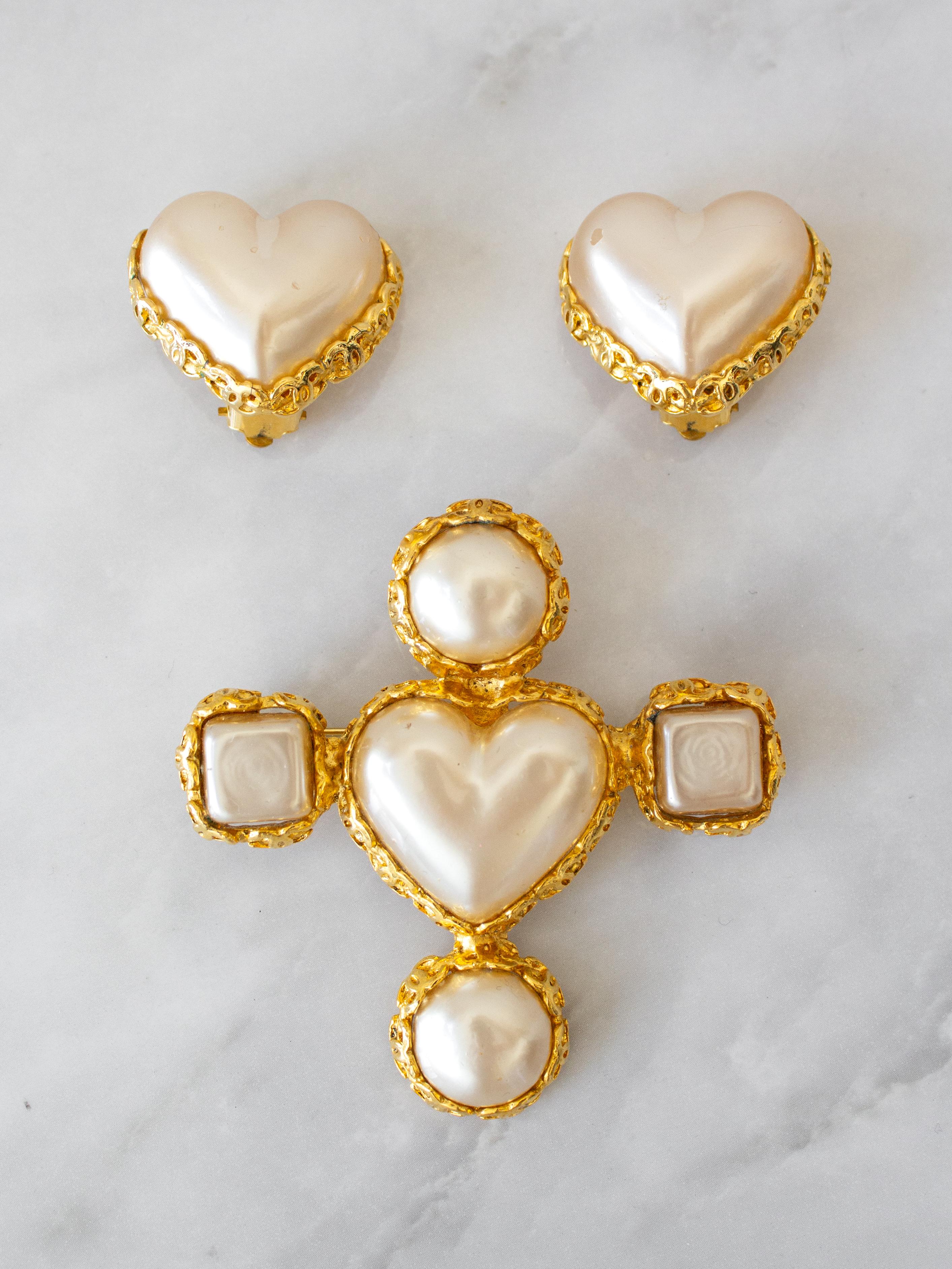 Introducing a truly exceptional find: the Chanel Spring/Summer 1992 Collection 28 earrings and brooch set. Crafted with meticulous detail, this exquisite ensemble features faux pearls adorned with gold-plated metal CC trims. 
Designed by the