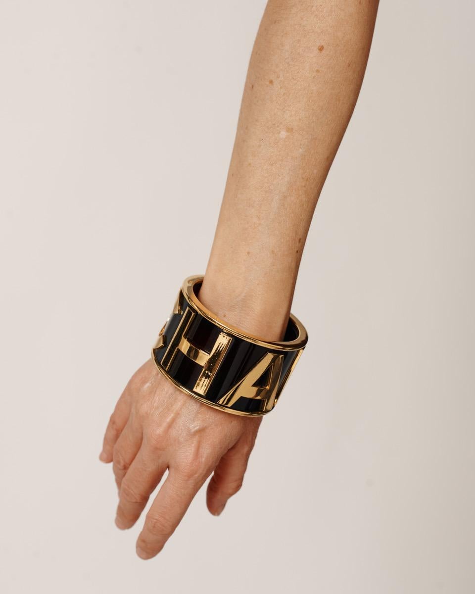 Alerte aux objets de collection ! Rarissime bracelet-bracelet Chanel by Karl Lagerfeld C H A N E L initials, datant du début des années 90. Fabriquée en lucite brune et en métal doré, cette 