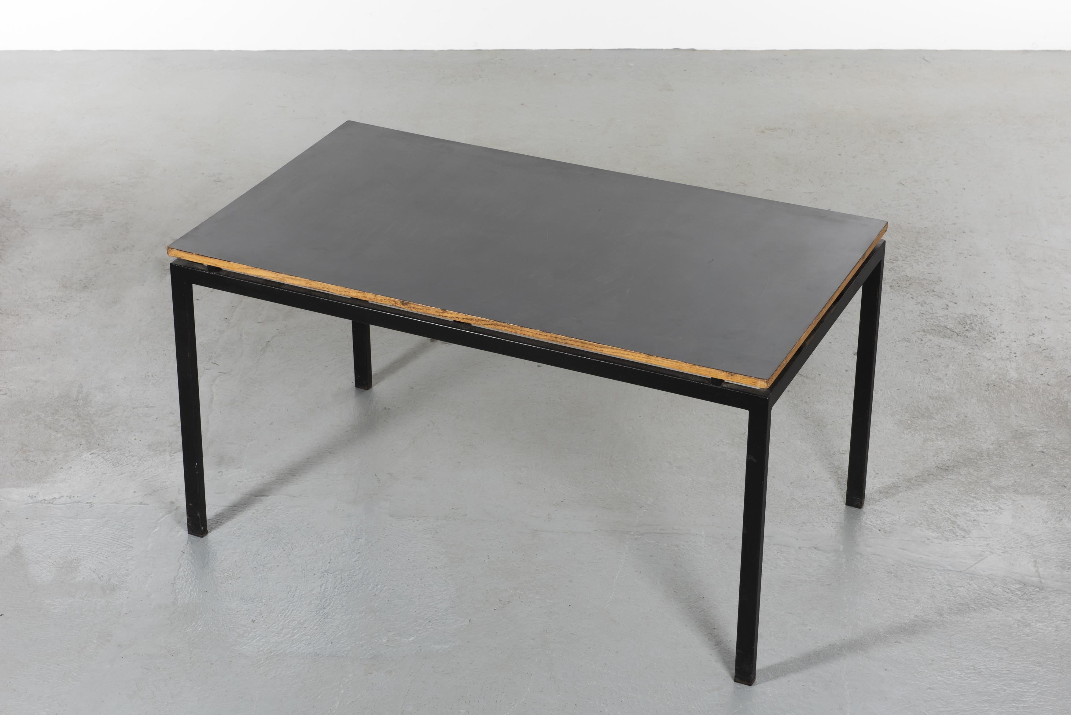 Charlotte Perriand (1903-1999)
Refectory table with a base in black lacquered metal and grey laminate plywood top. This table was made for the cafeteria of Miferma's engineers in the mining town of Cansado in Mauritania.

Measures: H 74 cm, L 140