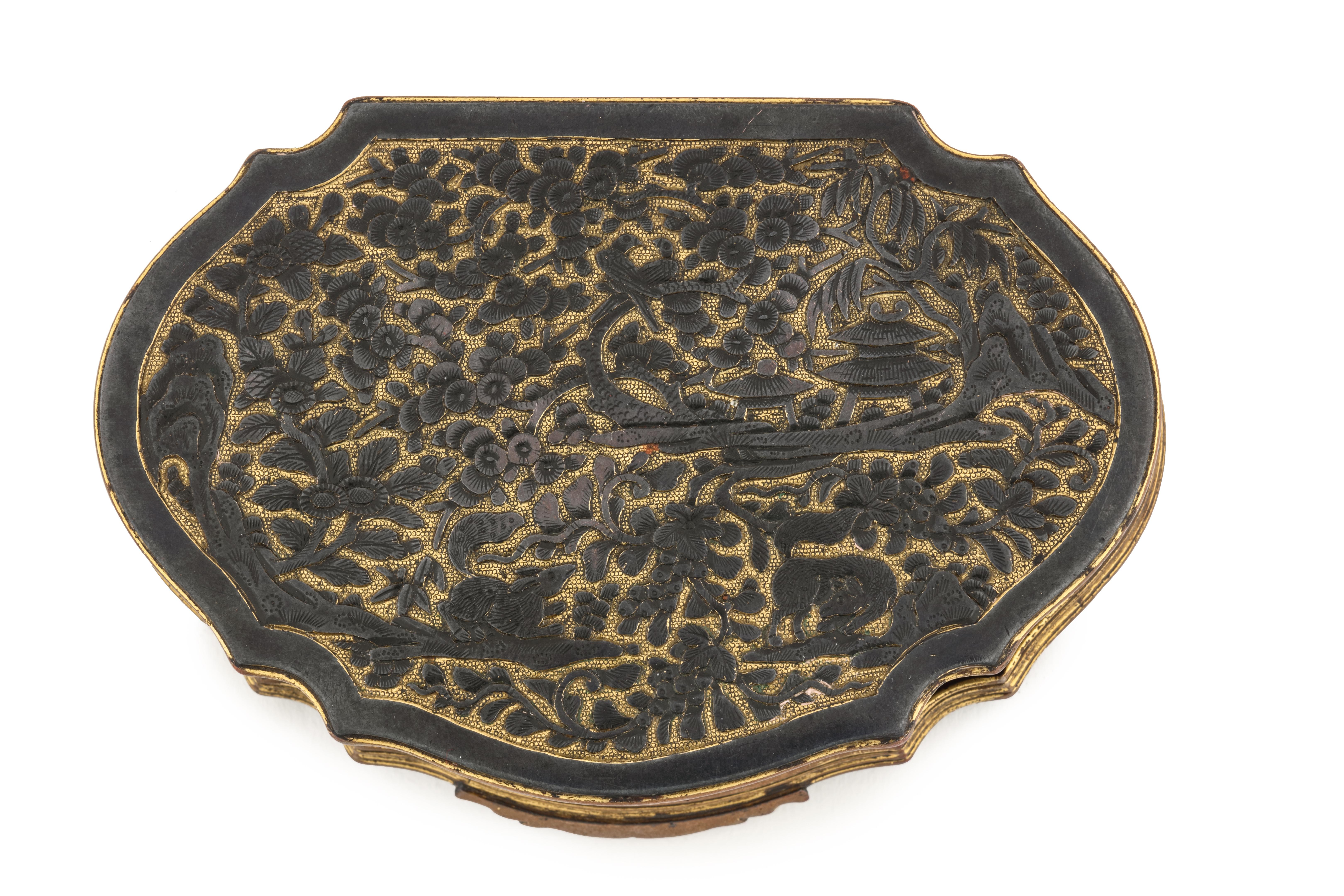 Eine erotische Tabak- oder Schnupftabakdose im Shakudo-Stil in Ruyi-Form, mit Reliefdekor und versilberten Figuren

Möglicherweise Jakarta (Batavia), erste Hälfte 18. Jahrhundert

Maße: H. 2,2 x L. 12,1 x B. 8 cm

Diese Schachtel ist ganz im