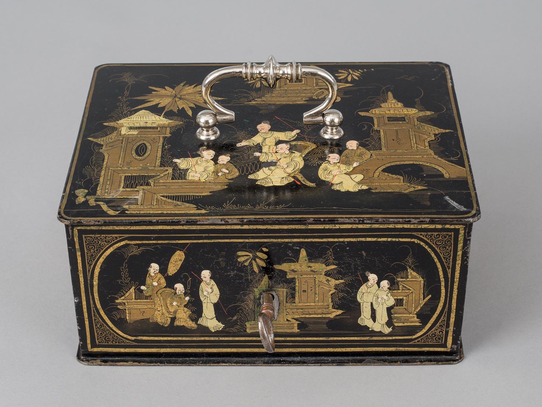 A charming chinoiserie lacquered steel strong box boldly decorated with figures in palace scenes with gilded pagodas, on a black background. It has a shaped Georgian style swan neck silver handle atop the box. The box retains its original blue