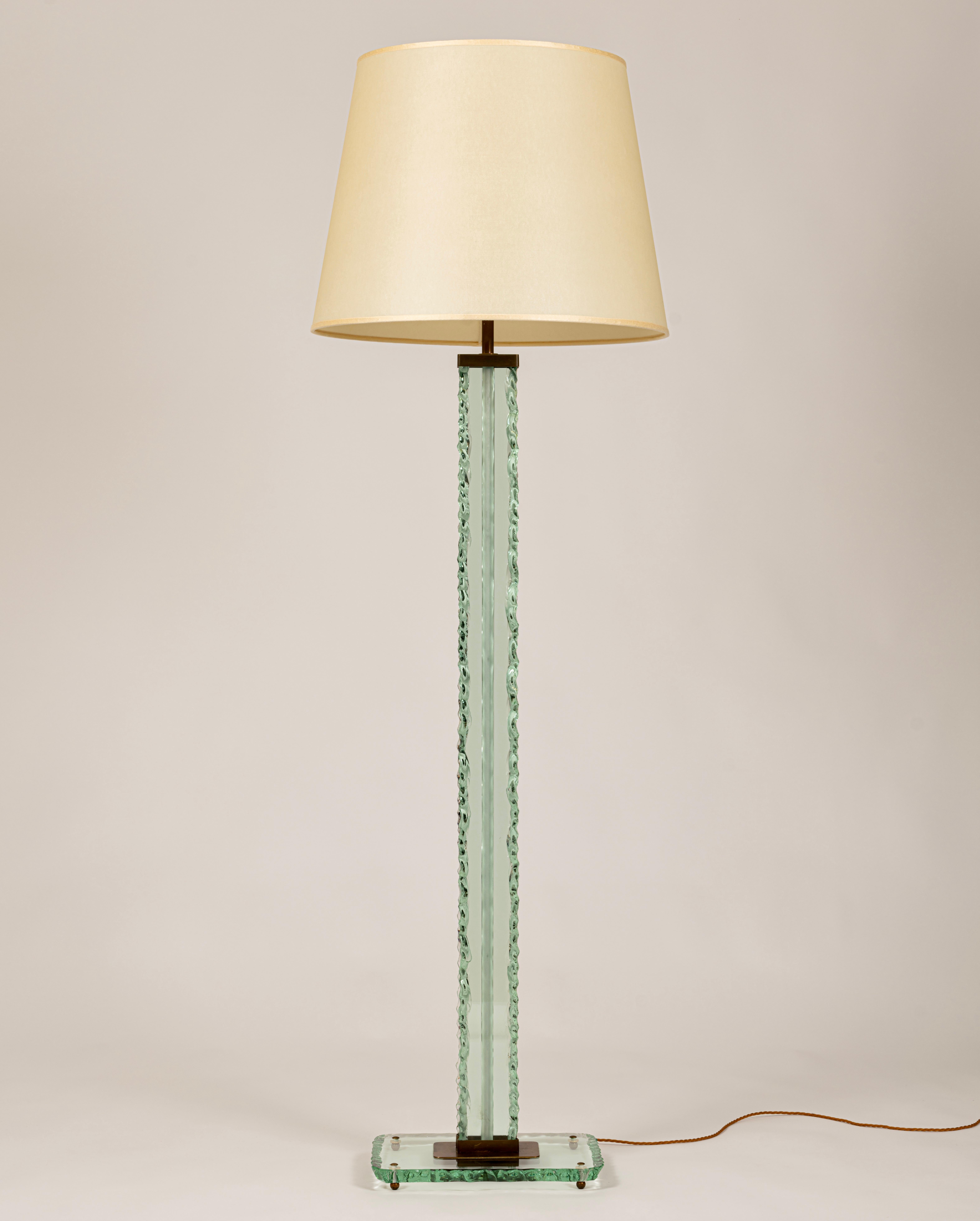 A rare, chiseled and polished glass floor lamp designed by Pietro Chiesa, Italy, c.1935. This early design by Fontana Arte has a thick 'scalpellato' (chiseled) glass stem and sits on a rectangular glass base with four brass feet. A frosted glass