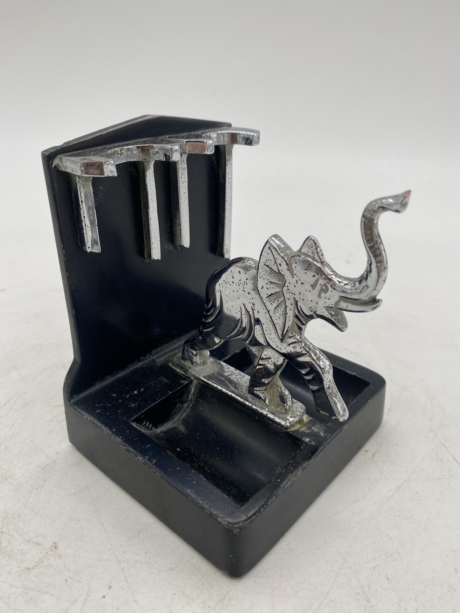 A ronson elephant two pipe holder with a chrome elephant and accents with a black powder coat base. It is listed in advertisement 