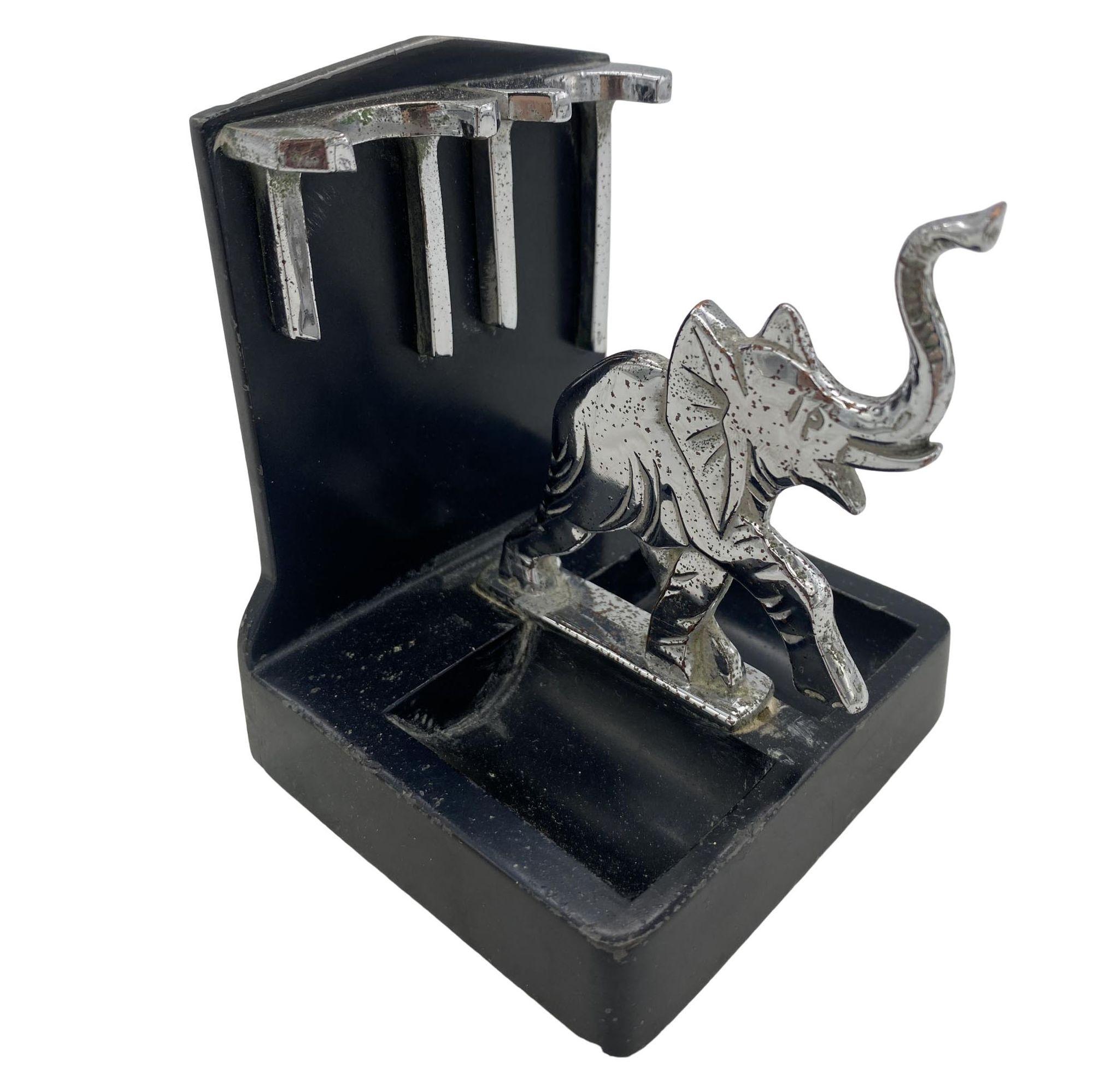 Un porte-pipes éléphant ronson avec un éléphant chromé et des accents avec une base en poudre noire. Il est répertorié dans la publicité 