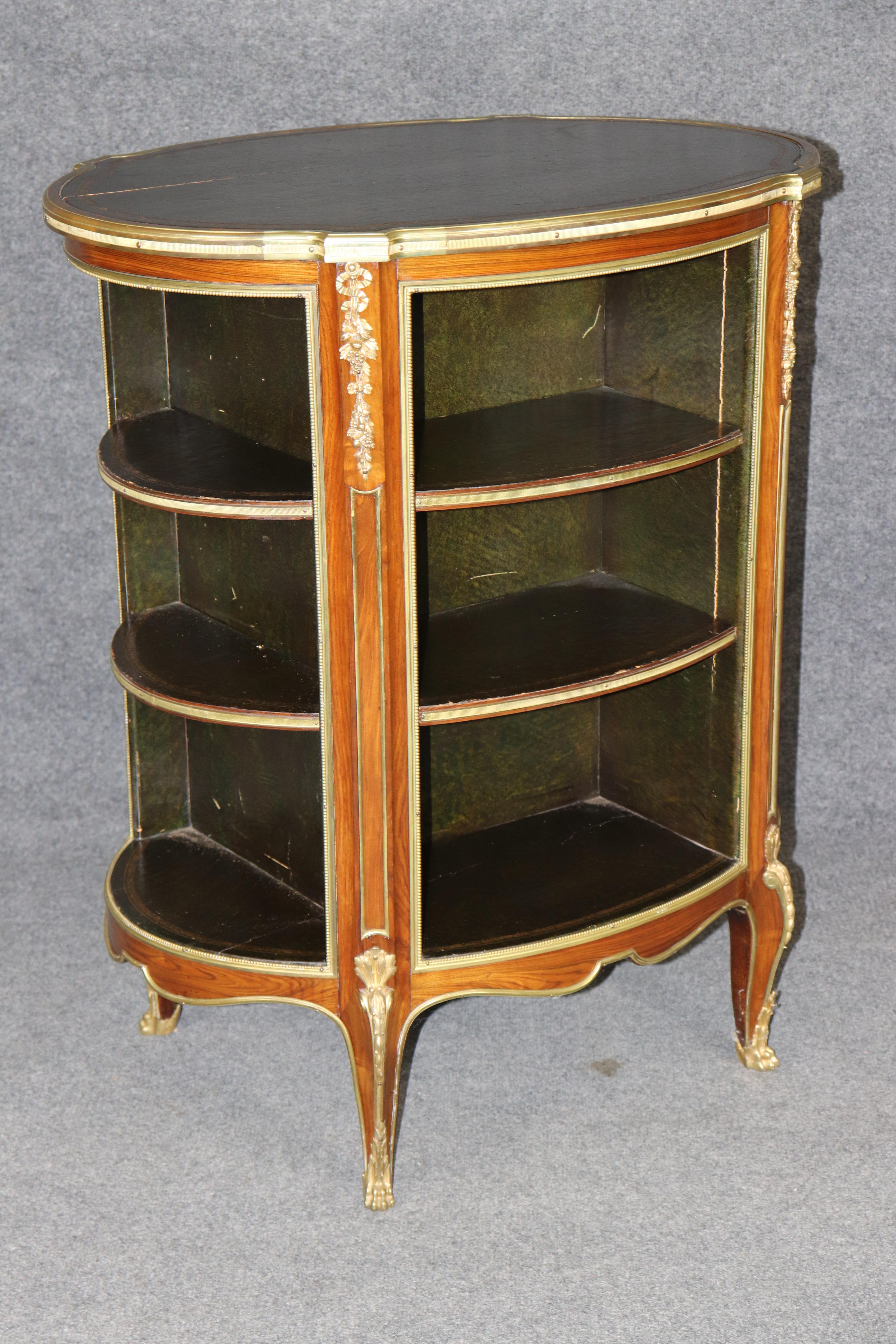 This is a superbly crafted and rare circular bookcase made in the Louis XV style. The bookcase has openings on all sides for books and a leather top with gold embossing for candles or lamps. The piece is absolutely gorgeous and a rare gem to place
