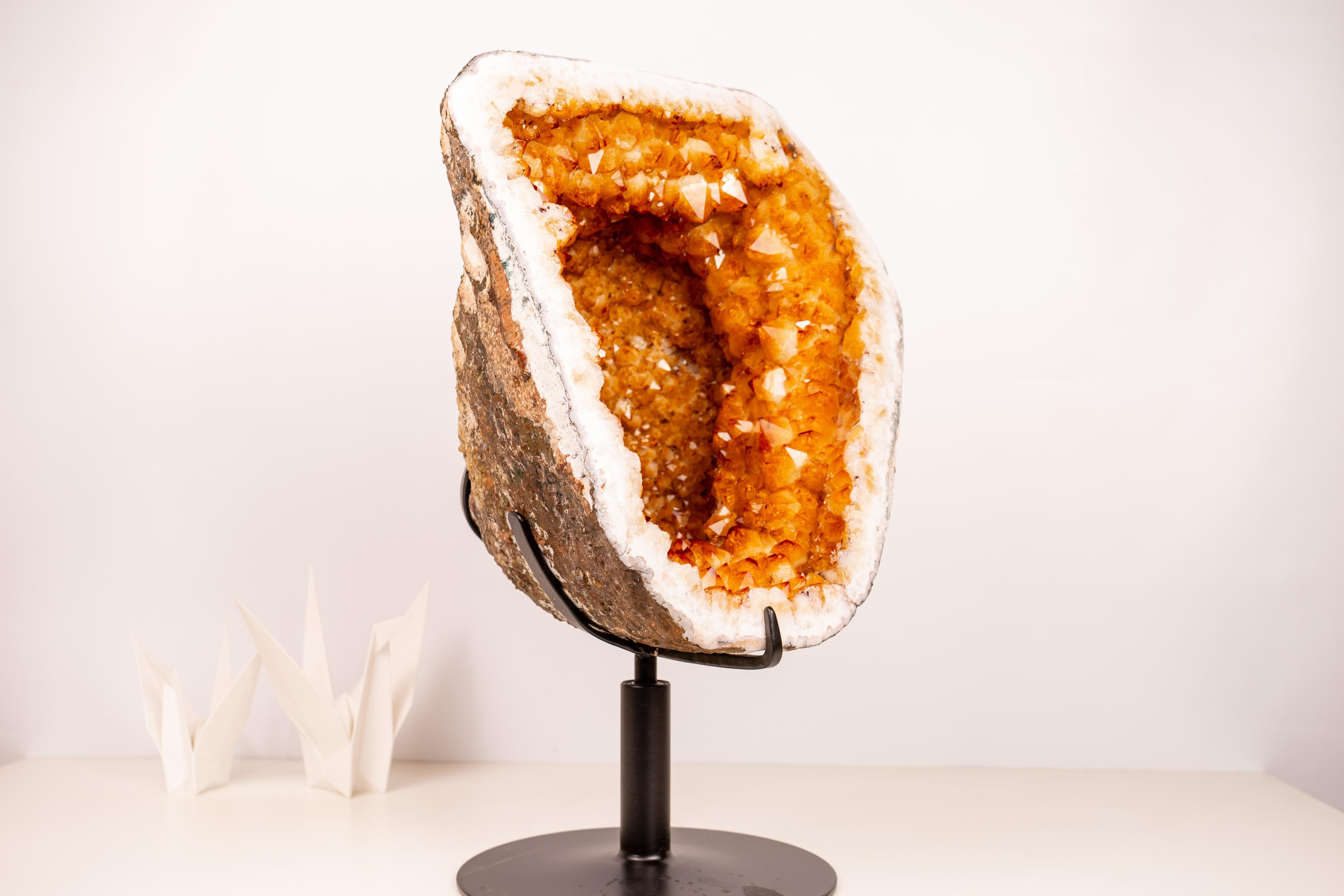 Géode de citrine avec une rare formation de couronne et une couleur orange doré étincelante sur un support rotatif

▫️ Description

Cette géode de citrine rare, d'une esthétique exceptionnelle, présente une symphonie de pointes de cristal brillantes
