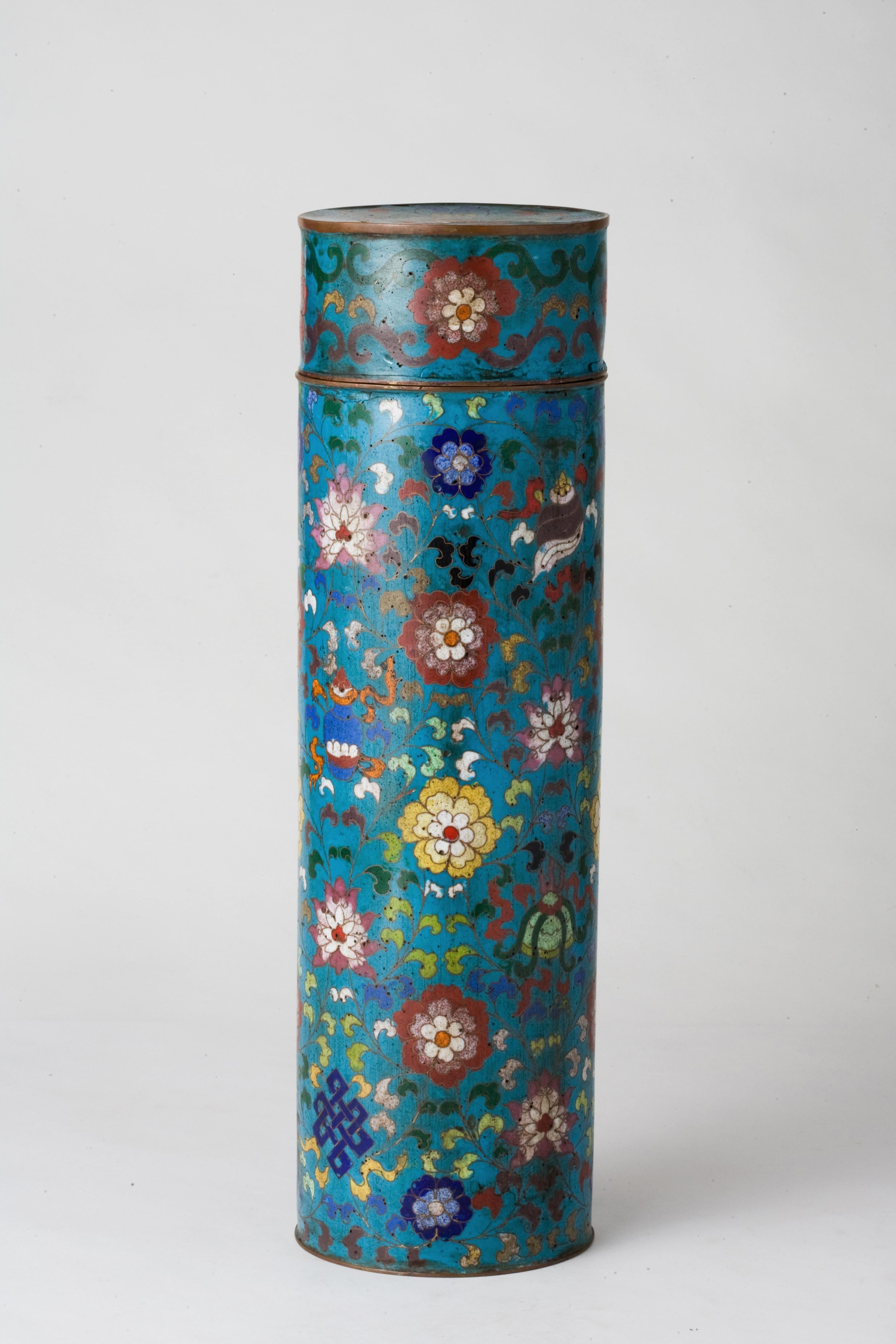Ce vase exquis est un bel exemple de cloisonné de la dynastie Ming, une époque réputée pour avoir révolutionné la technique du cloisonné avec un design complexe et un travail d'émail vibrant. Le vase cylindrique est méticuleusement orné de motifs