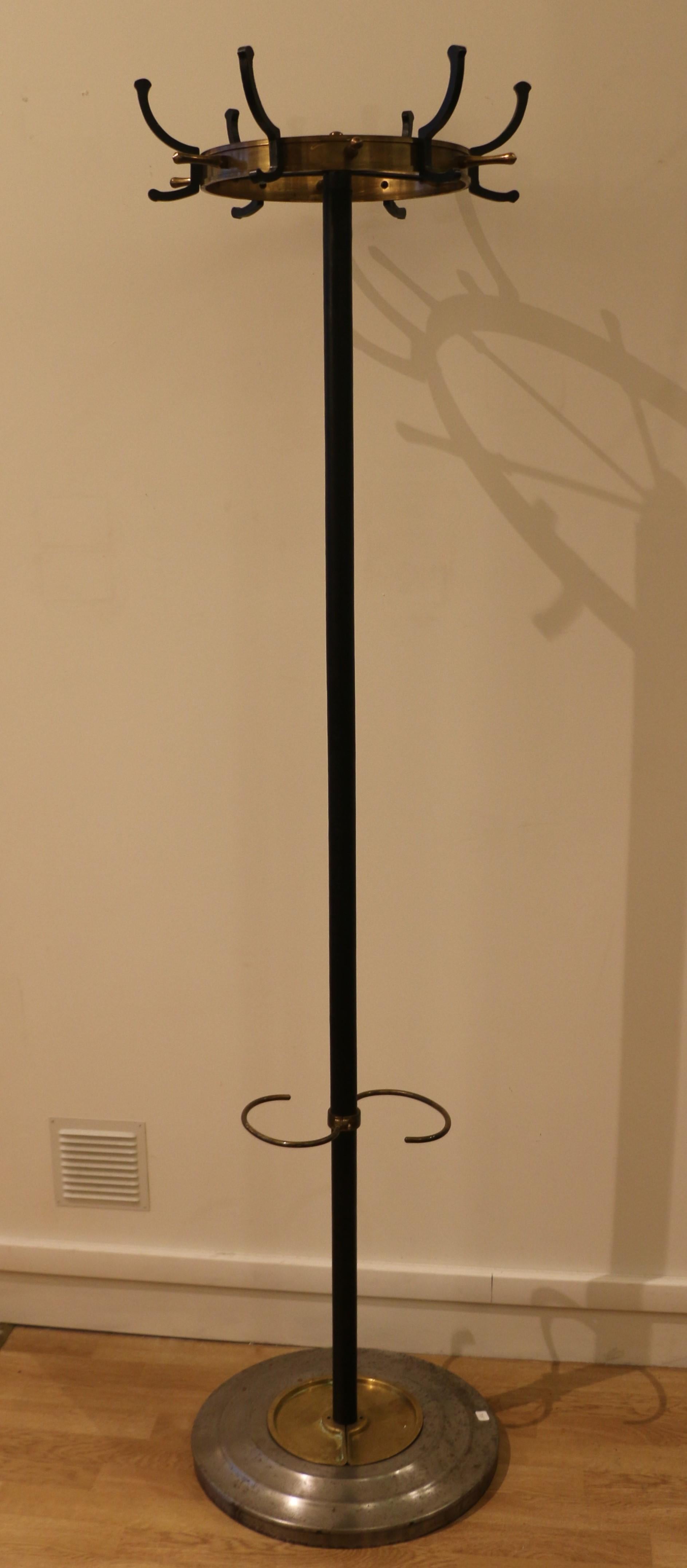 This furniture is typical of Jacques Adnet's work in the early 1950s.
This coat stand allows to suspend up to 18 garments. It is also an umbrella stand.
The base is made of steel, with two removable brass plaques. The shaft is covered with leather