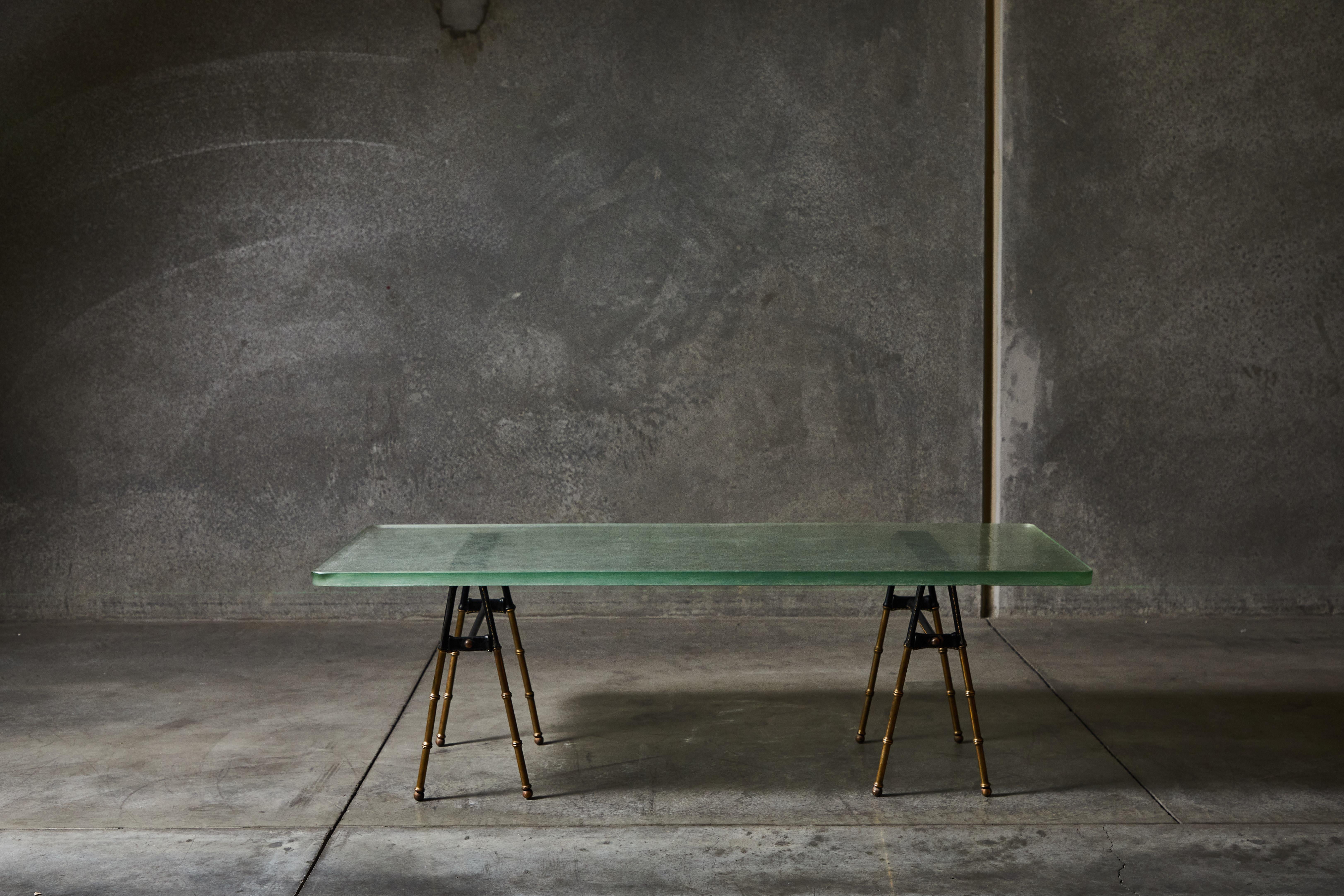 Stitched leather, brass and original green glass coffee table by Jacques Adnet. Made in France circa 1950s.