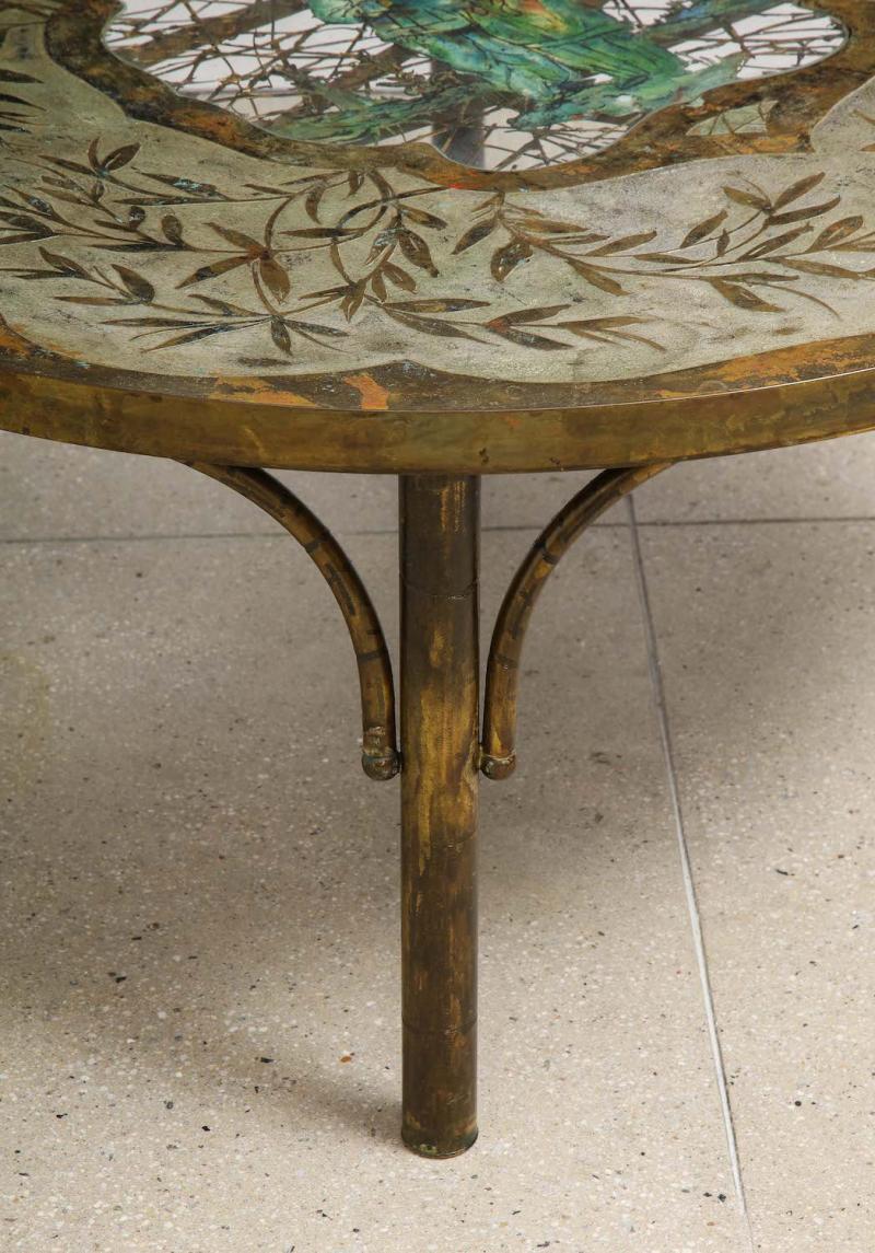 Rare Cocktail Table by Philip & Kelvin LaVerne.  Bronze, pewter, enameled paint, glass. Circular table with tubular legs and faux-bamboo supports. Top with Asian themed figures and decoration. Cut-outs to the center with inset glass covering.