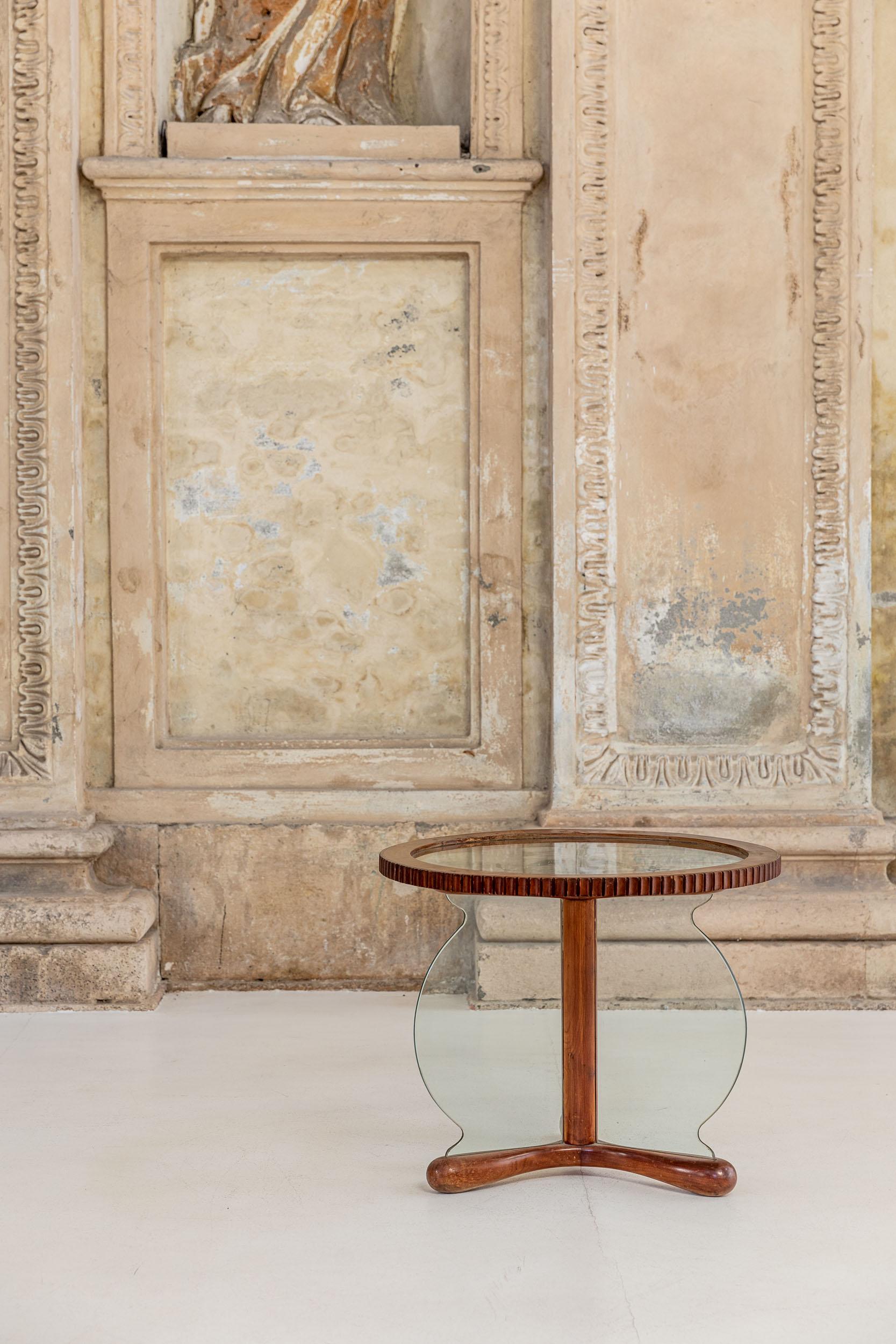Table basse en bois et verre attribuée à Osvaldo Borsani. 
Elegant table basse avec une forme particulière composée d'un plateau circulaire et d'une base unique, tous réalisés en verre et bois finement décorés, la base a également un détail en