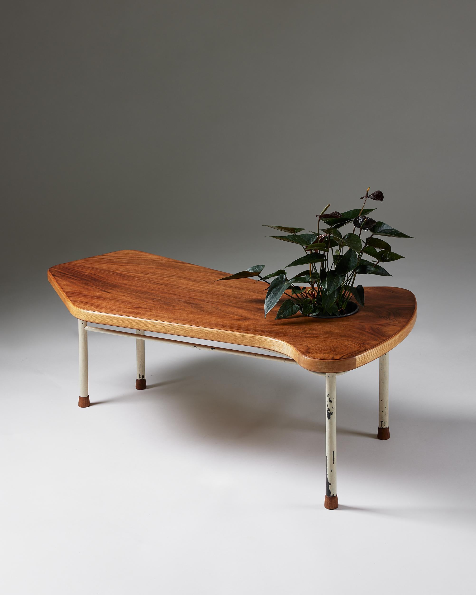 Coffee table designed by Finn Juhl for Niels Vodder,
Denmark, 1941.

Walnut-veneered wood, ash, walnut, painted steel, and aluminium.

Only two of these coffee tables with an integrated planter are known to have been made.

Provenance: From a
