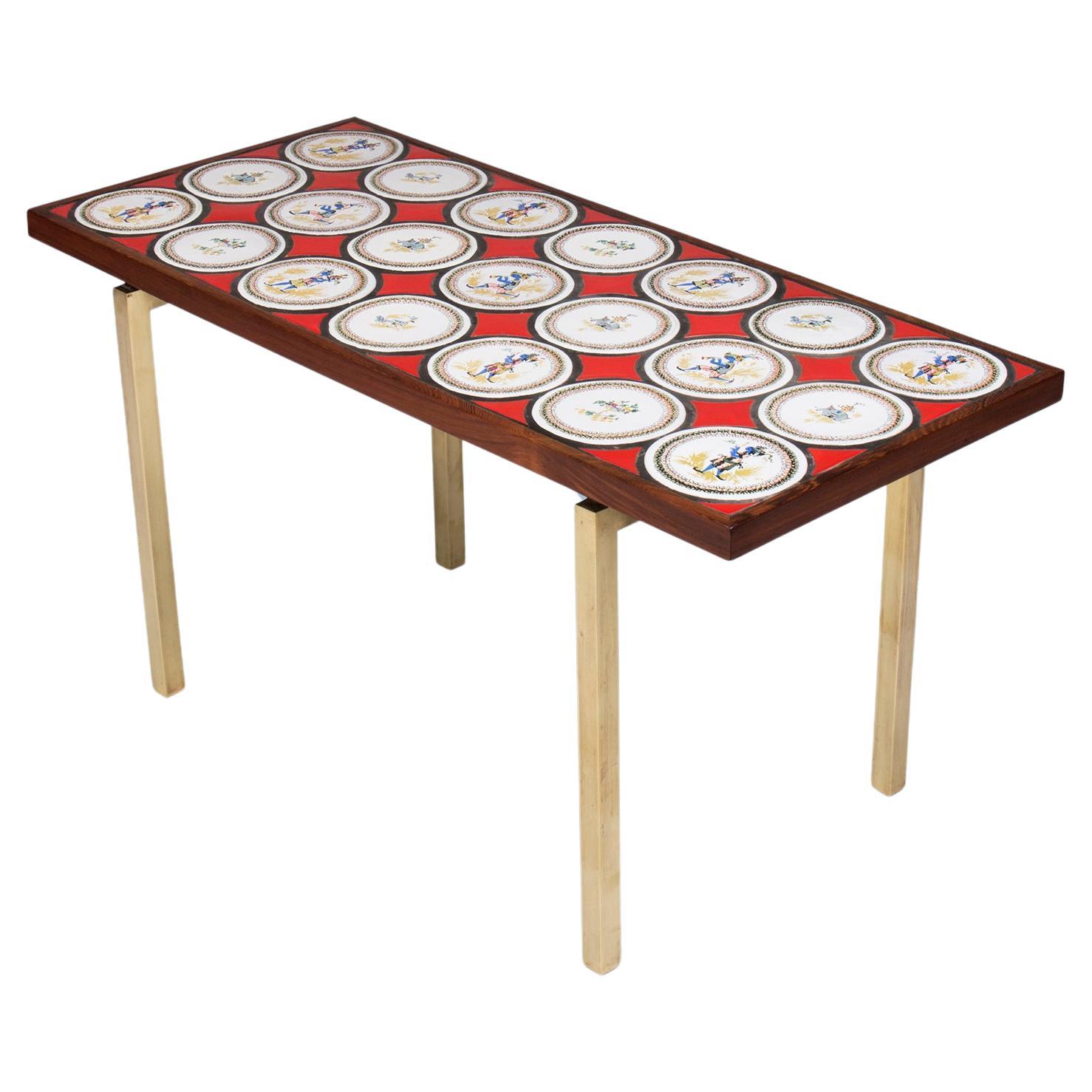 Table basse danoise moderne avec carreaux de bleu rouge, nuances blanches et pieds en bronze