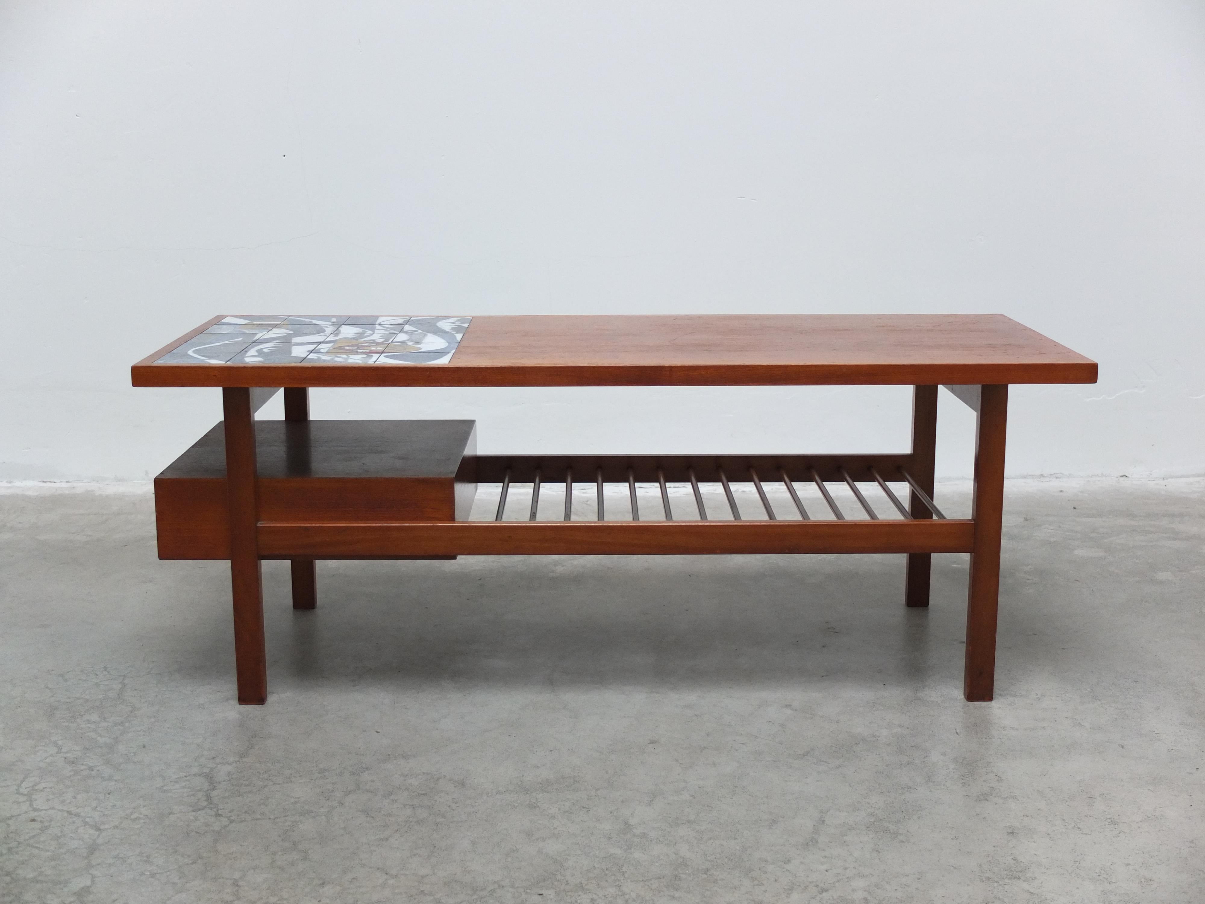 Einzigartiger Couchtisch, entworfen von Jos De Mey für Van Den Berghe-Pauvers in den frühen 1960er Jahren. Hergestellt aus Nussbaumholz mit einer schönen Keramikfliese auf der Oberseite. Darunter befindet sich ein Zeitschriftenregal und auf einer