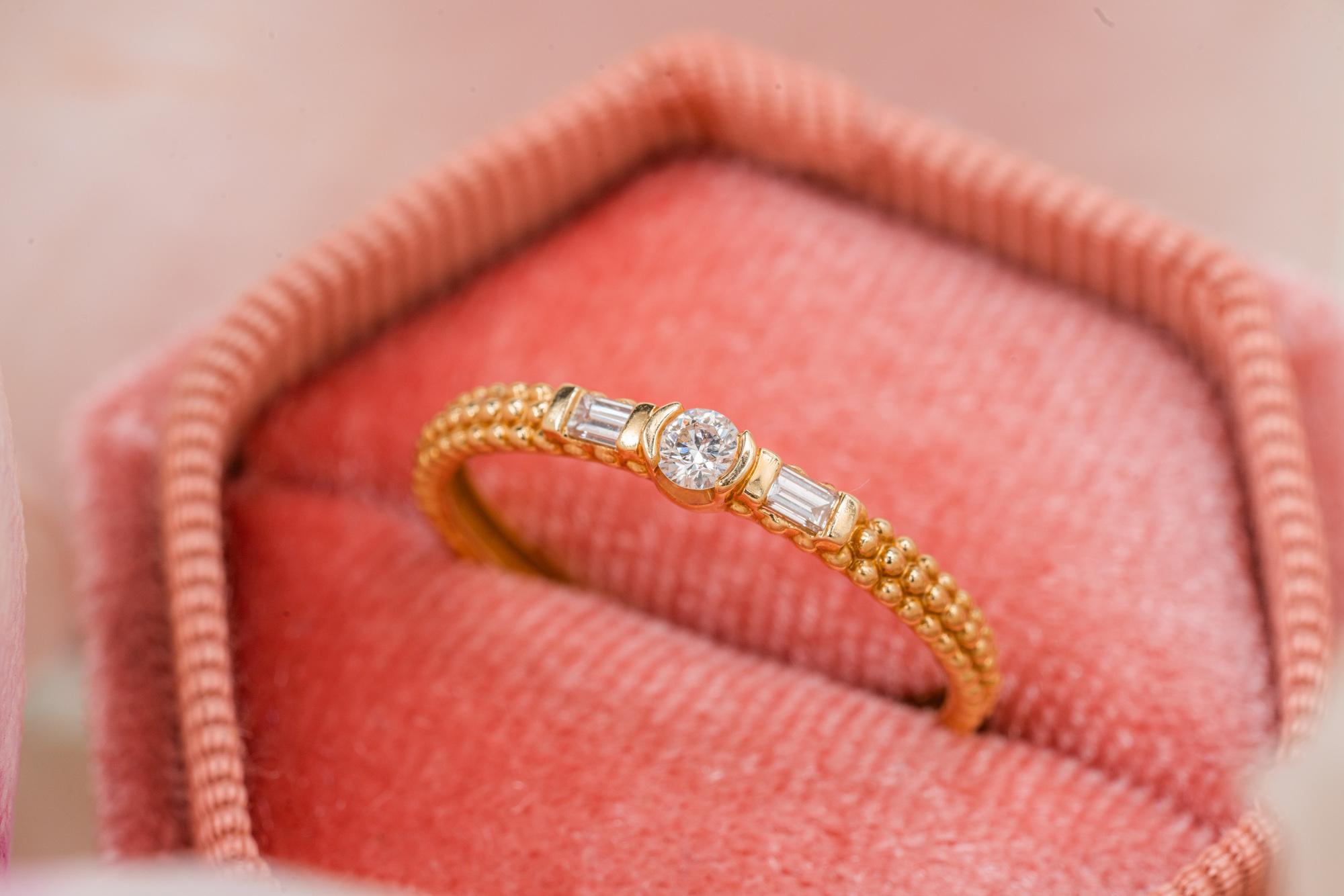 Such a classy and elegant three stone designer ring with sparkly diamonds and a bullet-work shank. This beautiful ring is made of solid 18kt gold and is produced by a famous French brand Maboussin.

The central stone is a delicate extremely clear