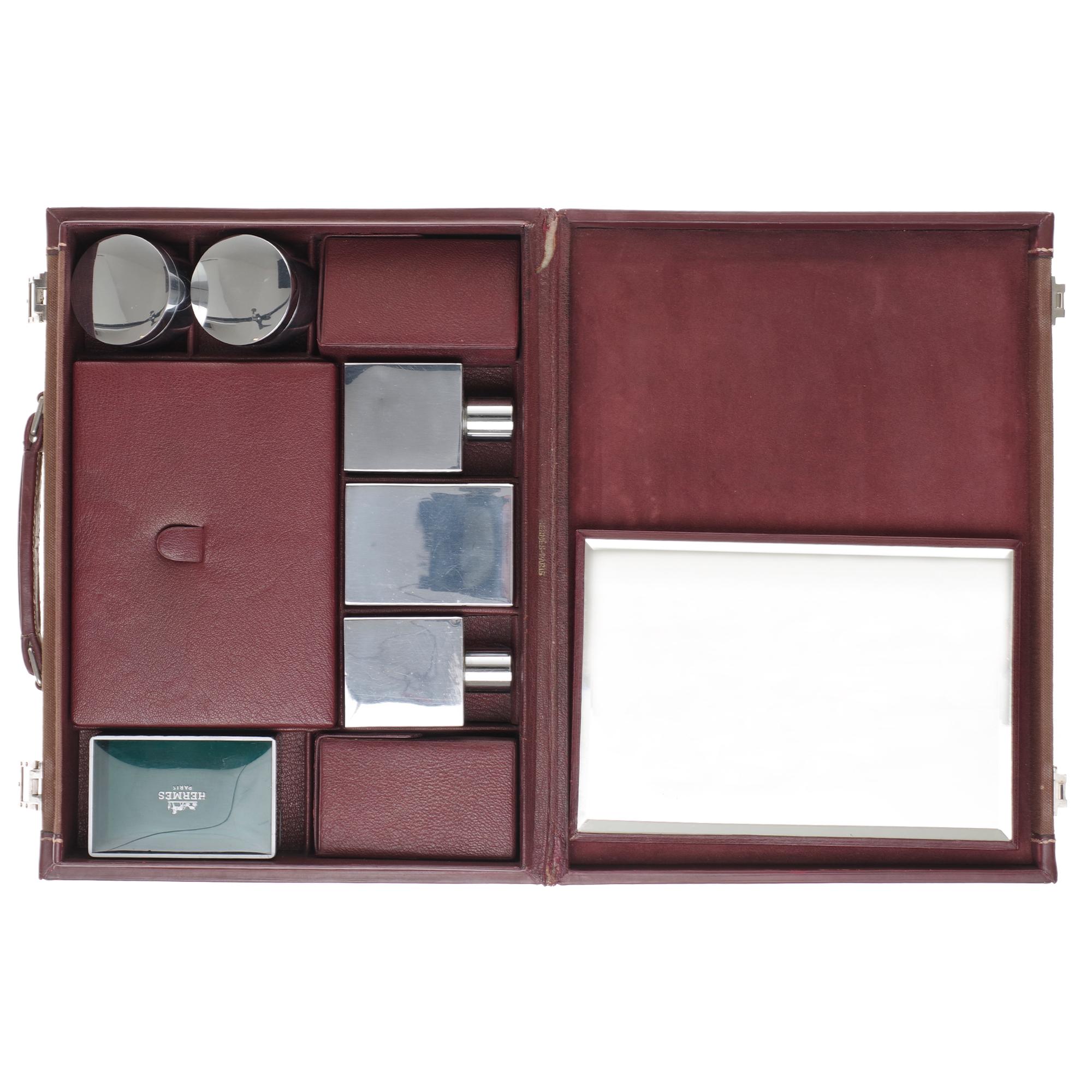Beautiful collector’s piece !

Hermès bi-material cosmetic case in burgundy leather and beige canvas, interior in burgundy suede
3 silver metal bottles, two round boxes
silver metal, 3 leather compartments, 1 green plastic soap box and a travel