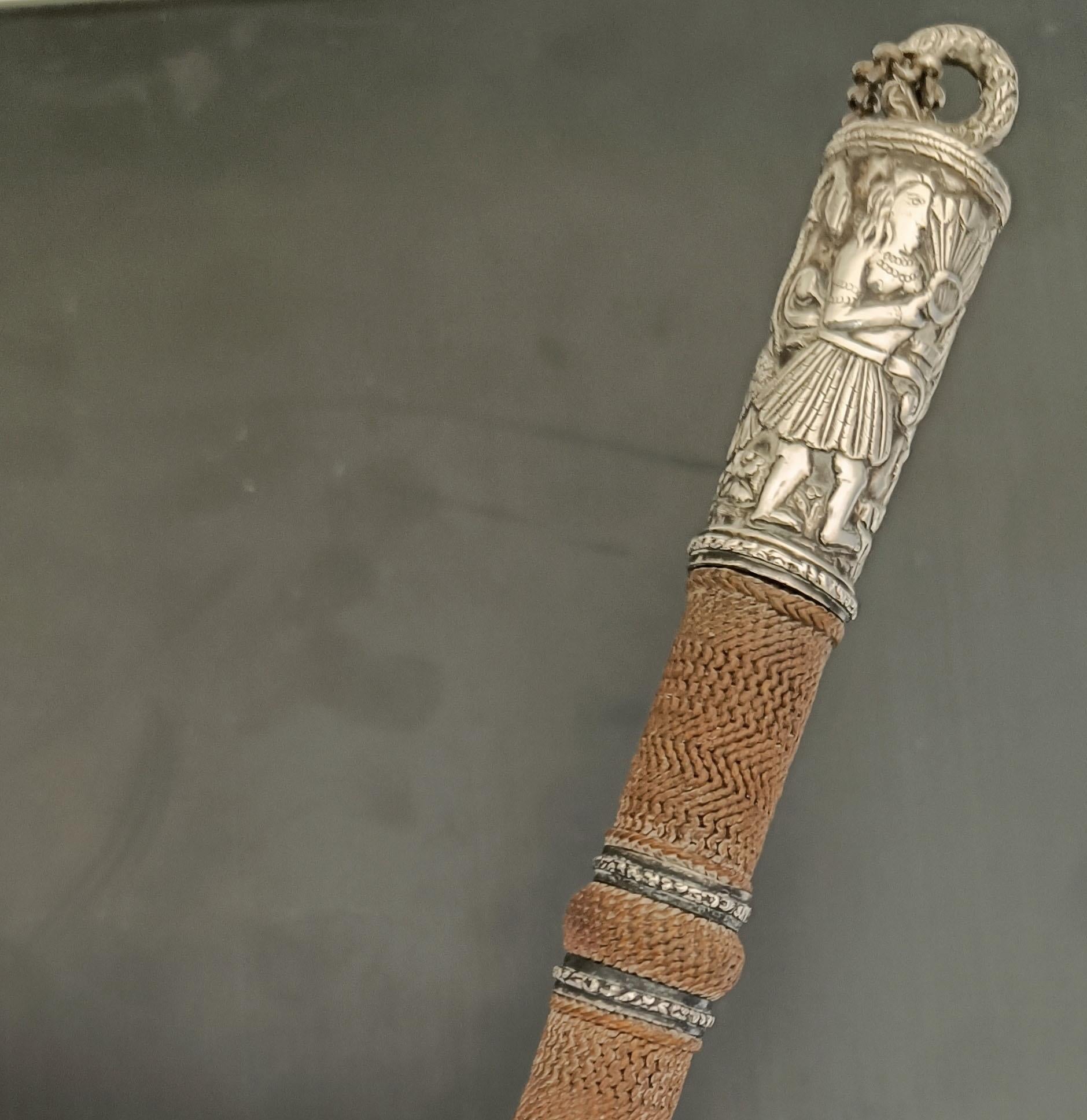Exceptionnelle et rare cravache ancienne, dotée de montures en argent superbement détaillées avec un décor ciselé et repoussé de figures et de feuillages, vraisemblablement fabriquée pour une personne de haut rang. La monture représente un