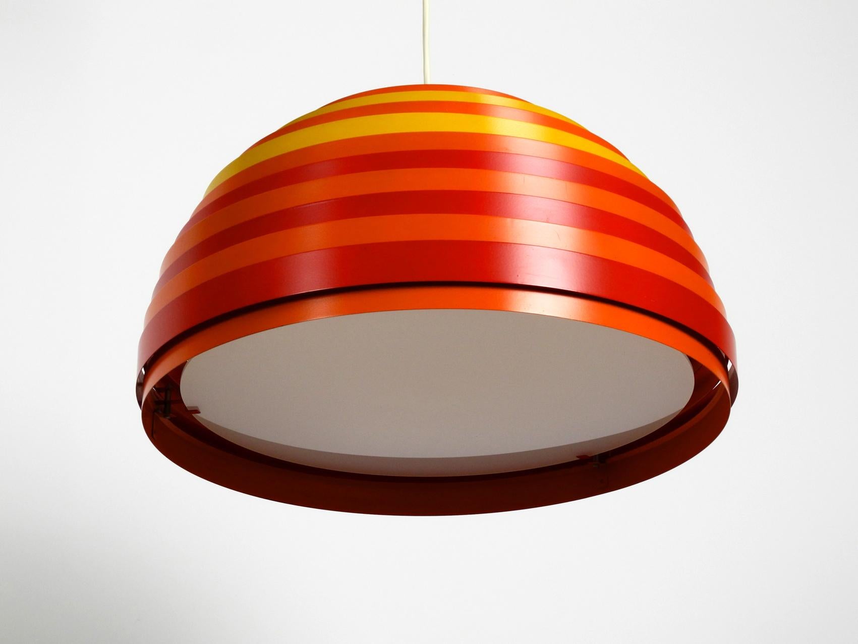 Very rare colorful Pop Art slats pendant light model Dynamic. Designed by 
Wilhelm Weste for Vest. Made in Austria. Exceptional high quality design. 
Circular colorful metal rings are connected with ropes. 
With a plexiglass diffuser below, for