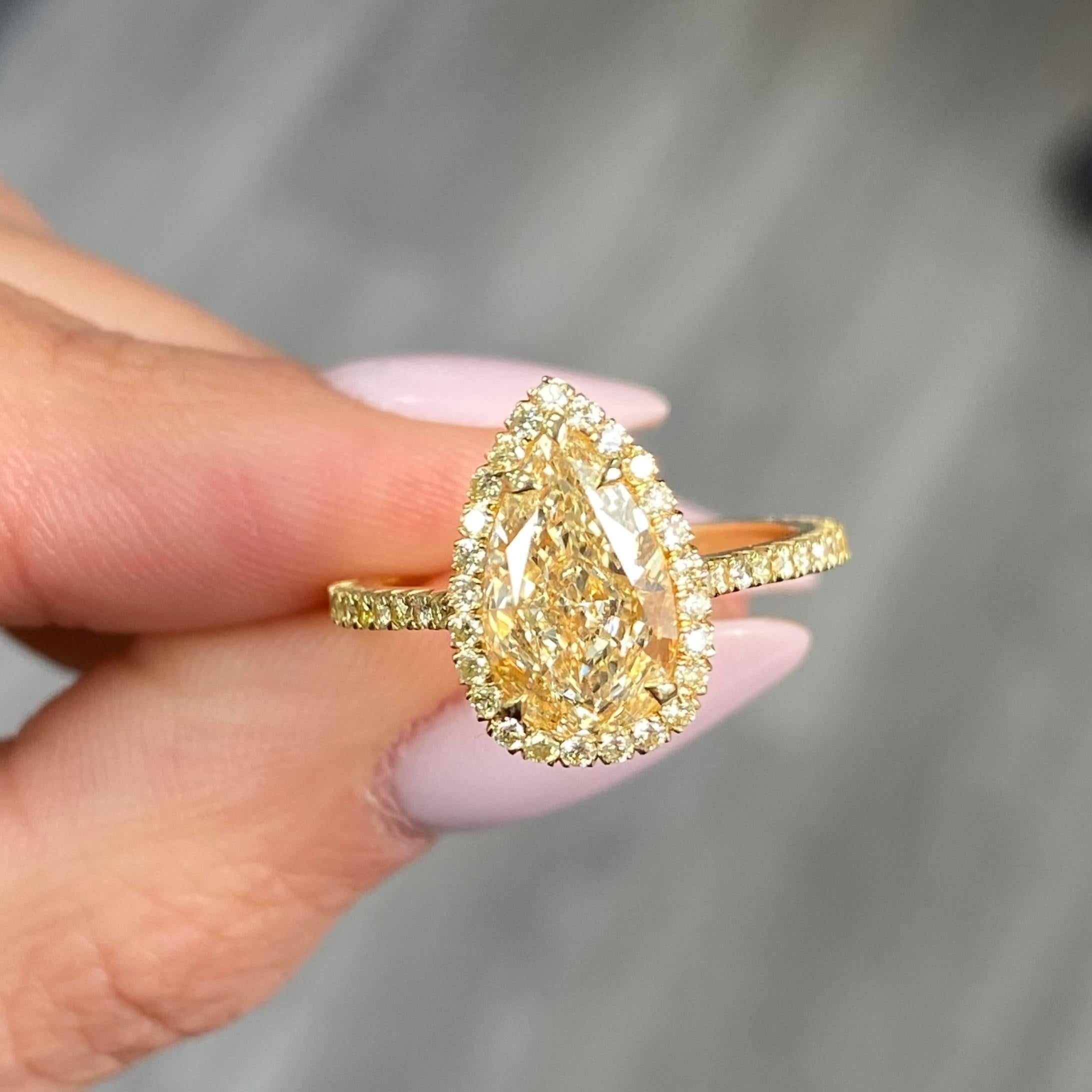 2.27 carats center light yellow (WX Color) diamond with Si1 clarity. Set in handmade 18 arat yellow gold ring with a yellow diamond halo and on half the shank. Ring size 6.5 and can be resized. 
GIA Certified diamond.
At Rare Colors, you can