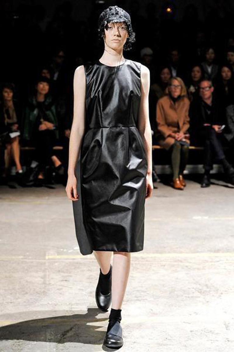 Spring 2011 CDG collection by Rei Kawakubo where she rearranged or appeared to turn clothes upside down. The dress being presented is made in 3 identically styled attached dresses: black shiny poly; navy wool; and a distressed grey nylon denim.  