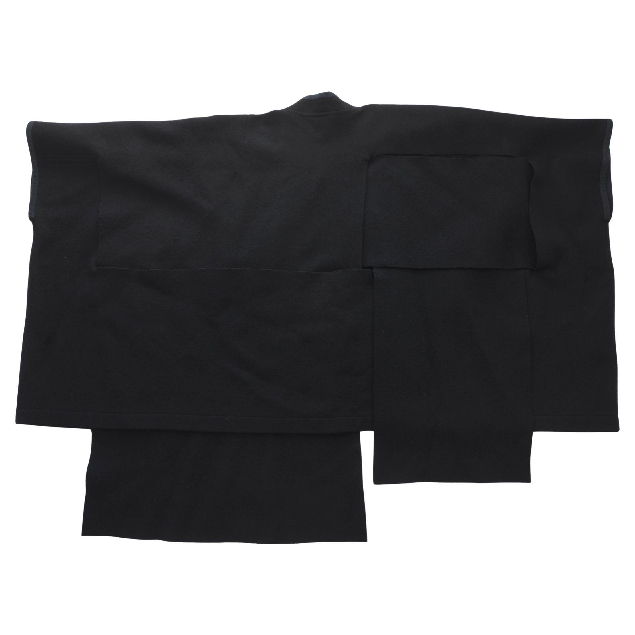 Rare Comme des Garcons Black wool felt coat made from rectangular panels woven together through large slits cut into the fabric. 
There are no buttons or fasteners.
Excellent condition for its age,CDG labels attached 
Amazing piece of history