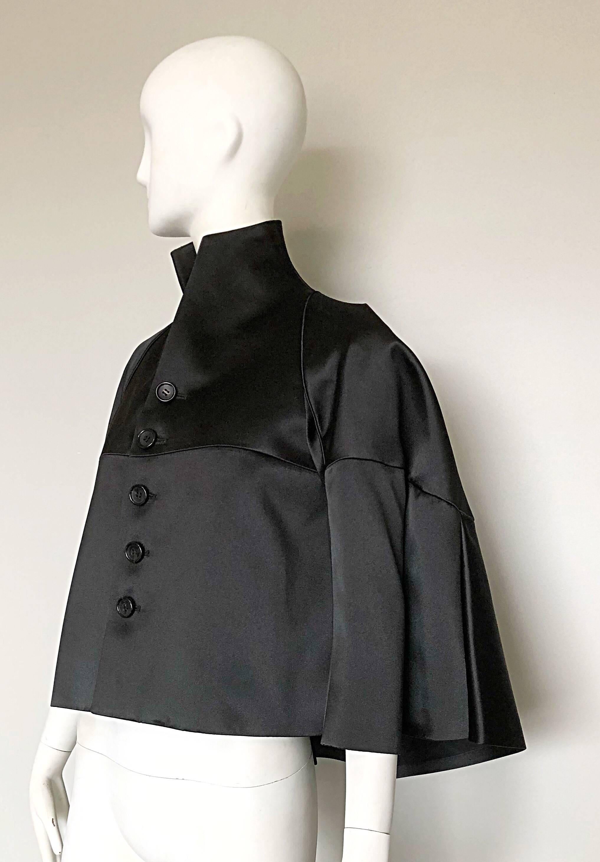 New mid 2000s COMME DES GARCONS / JUNYA WATANABE black Avant Garde jacket cape! Features a dramatic 1940s style high neck. Signature dramatic lines that hold shape nicely. A tribute to the soccer / football collection! Buttons up the front. 
So much