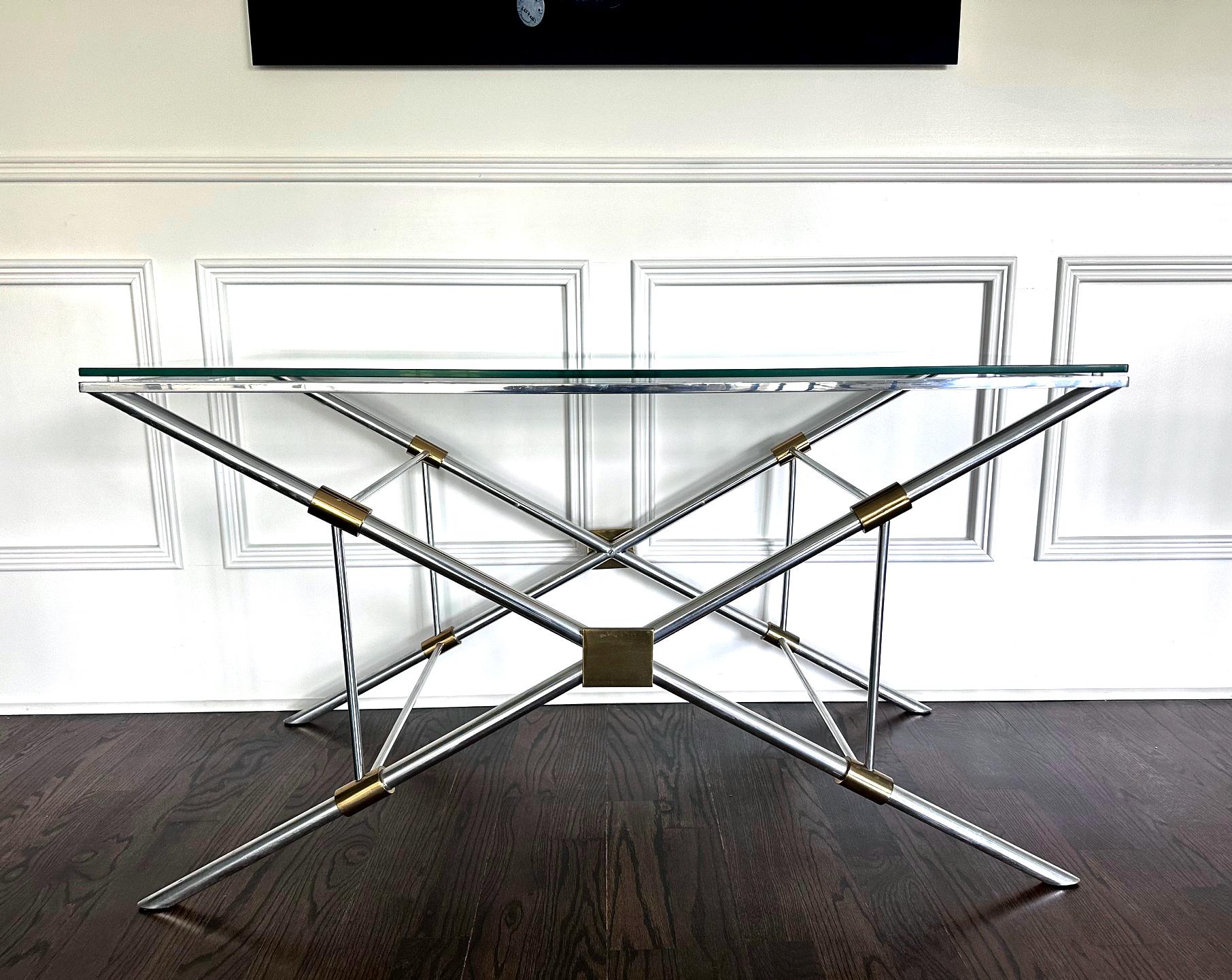 A console or sofa table by John Vesey (1924-1992) for John Vesey Inc. A rare model from the designer who reinvented classics for modern living. Constructed in polished aluminum with brass accent joint tubes and plates, the table support a conforming