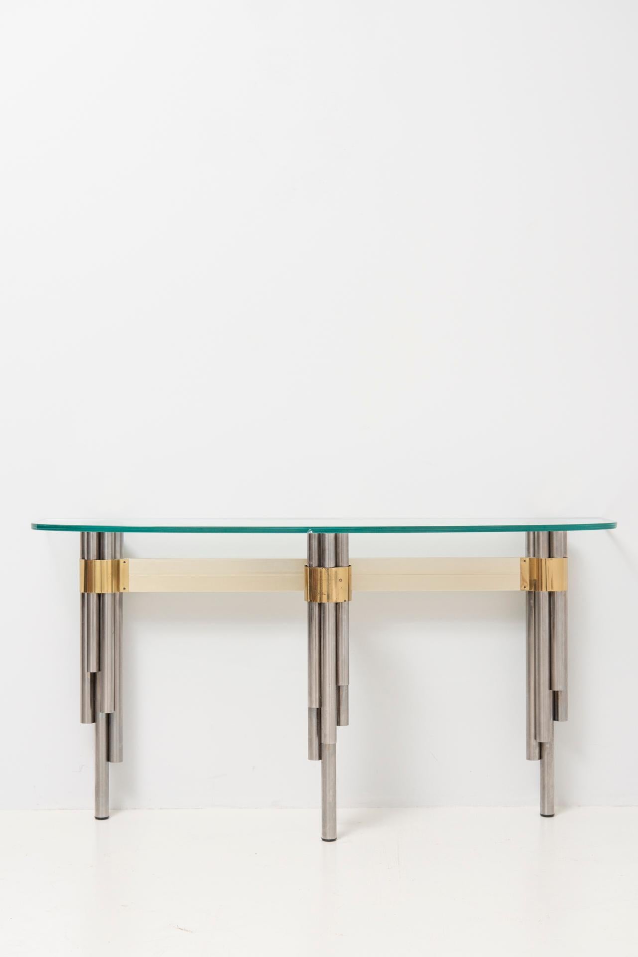 A very rare console table by French sculptor and designer Philippe Jean. The console table has a glass top and it’s tripod base is made of chrome plated tubular metal structures connected with a brass frame. Very good original condition, glass table