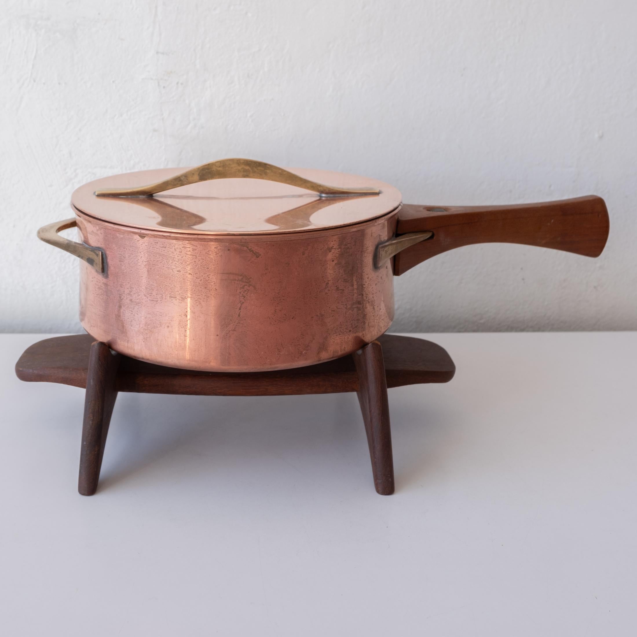 A rare copper cooking pot by Jens Quistgaard for Dansk. Complete with rare ceramic inner pot, removable teak handle and teak stand. Signed on the ceramic and stand. Made in Denmark, 1950s. 
