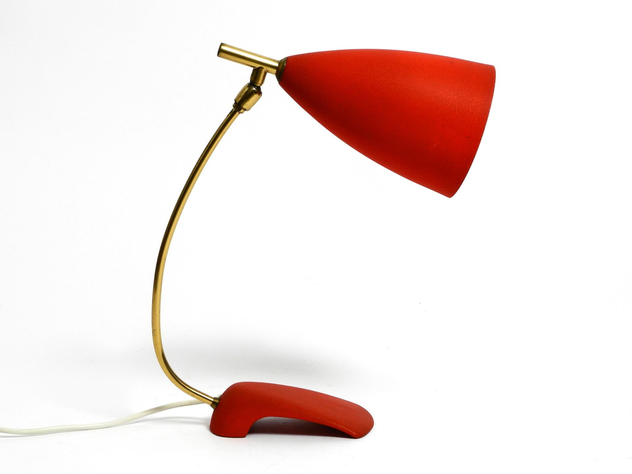 Beautiful, rare, large, mid-century table lamp from the German manufacturer Cosack.
Metal base and shade with fine red wrinkle finish and brass neck.
Shade infinitely adjustable.
Beautiful futuristic 50s streamline design.
Very good, well-kept