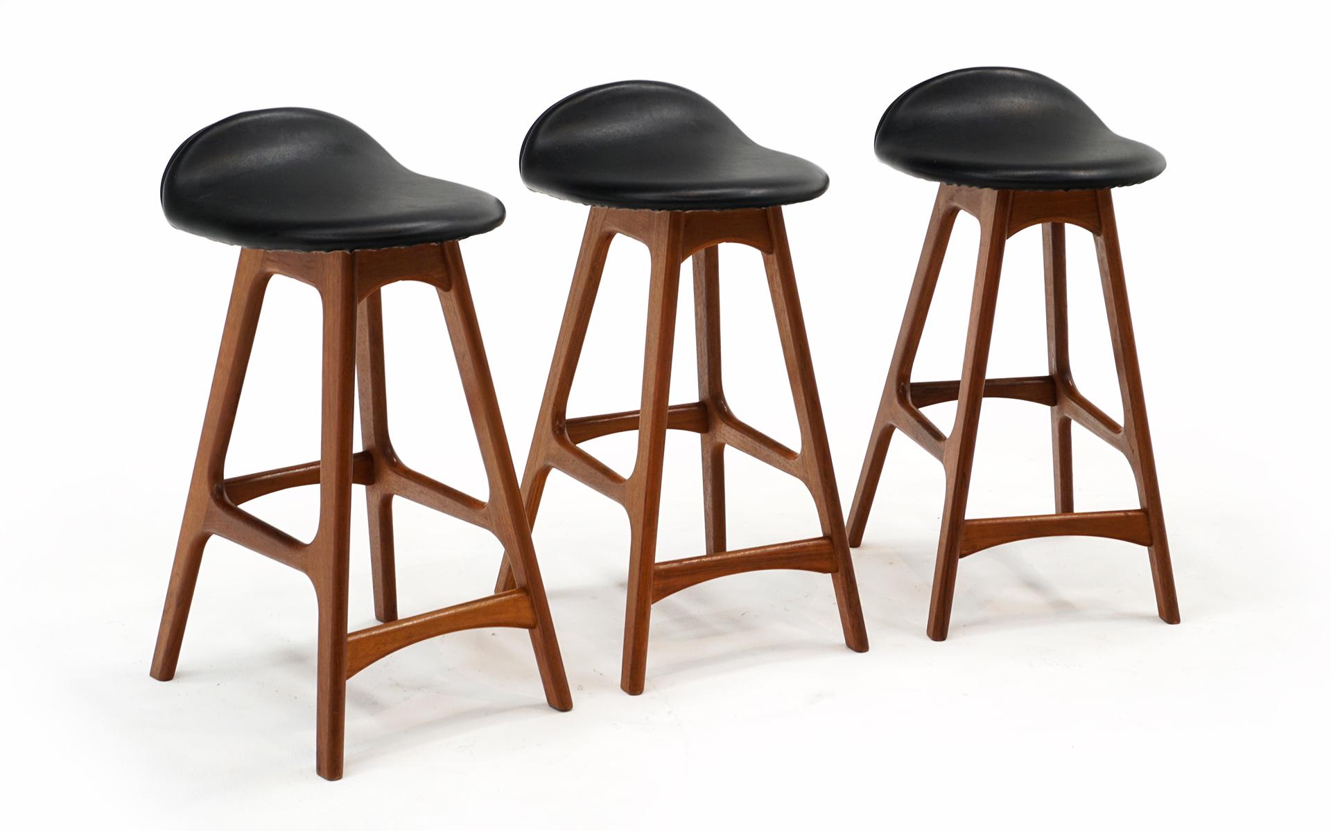 Very hard to find true counter height barstools designed by Erick Buch / Eric Buck. Danish Modern Teak frames with black leather like vinyl seats. Very good original condition with very few signs of use. The seats are free of any scuffs, tears,