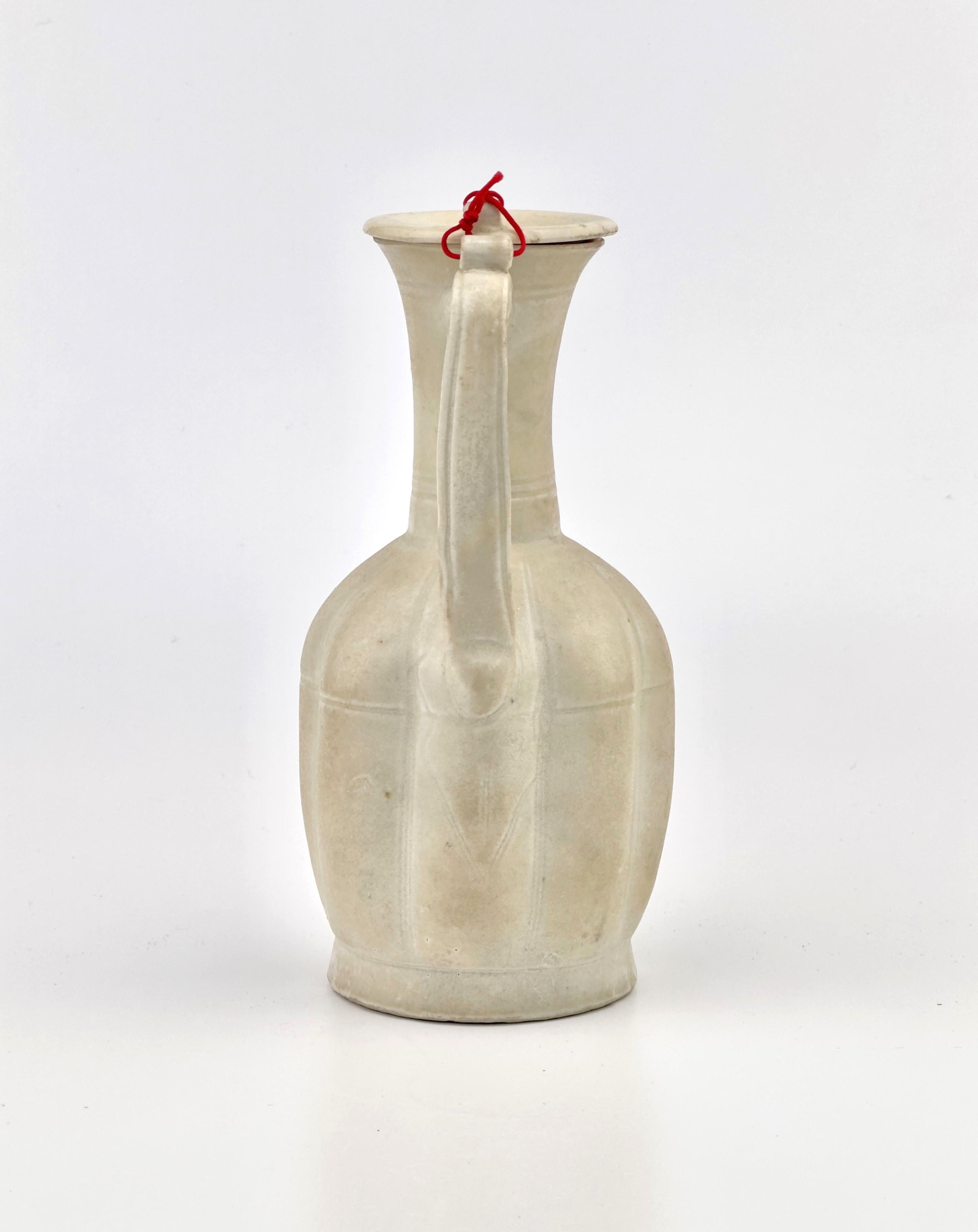 Es handelt sich um eine Keramikkanne aus der Song-Dynastie, die die charakteristische Schlichtheit und Eleganz dieser Zeit aufweist. Die Form der Kanne ist robust, mit einem vollmundigen Boden, der sich sanft zu einem schmalen Hals verjüngt und sich