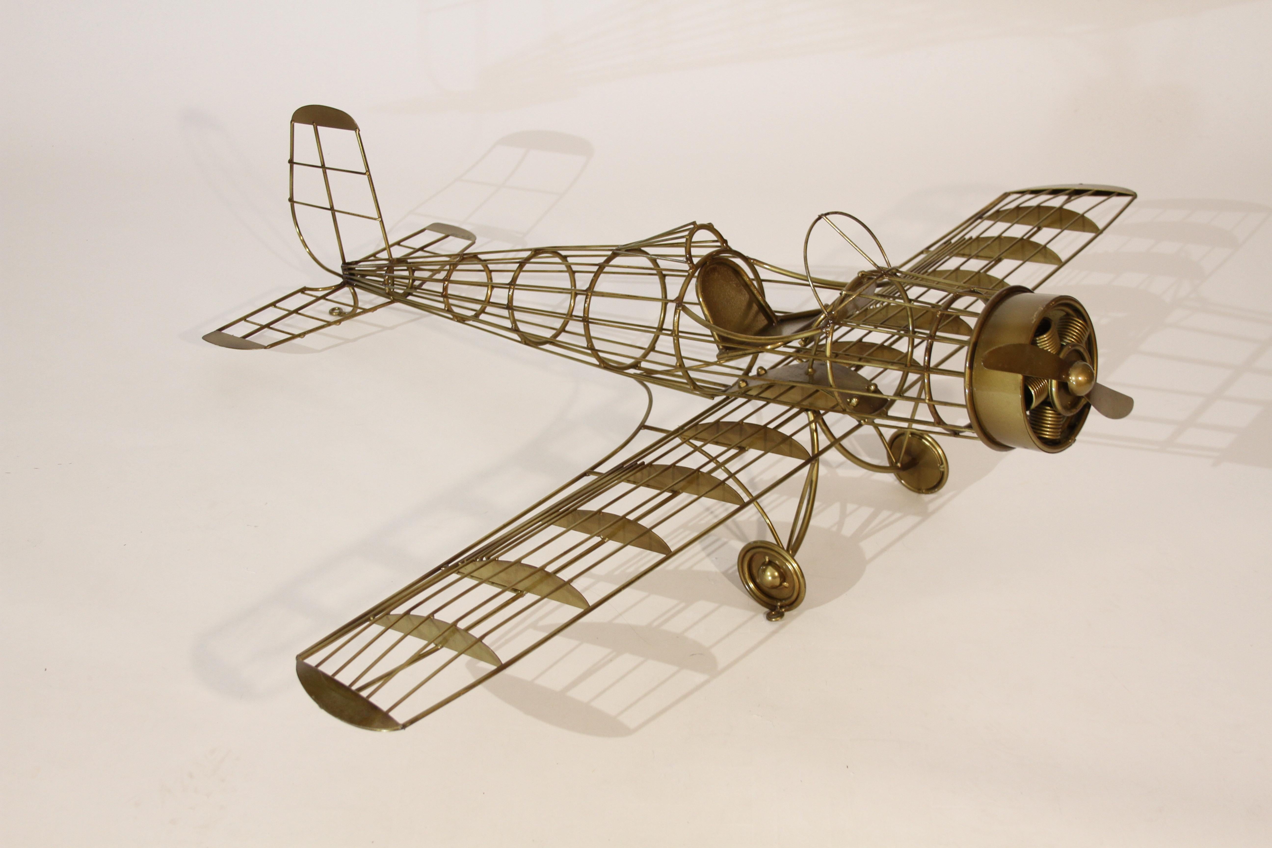 Large C. Jeré plane wall sculpture, very hard to find. Gold painted steel rods form the planes body, with open cockpit and spinning propeller. You can mount this on the wall to hang vertically or even suspend it from a ceiling. Signed and dated