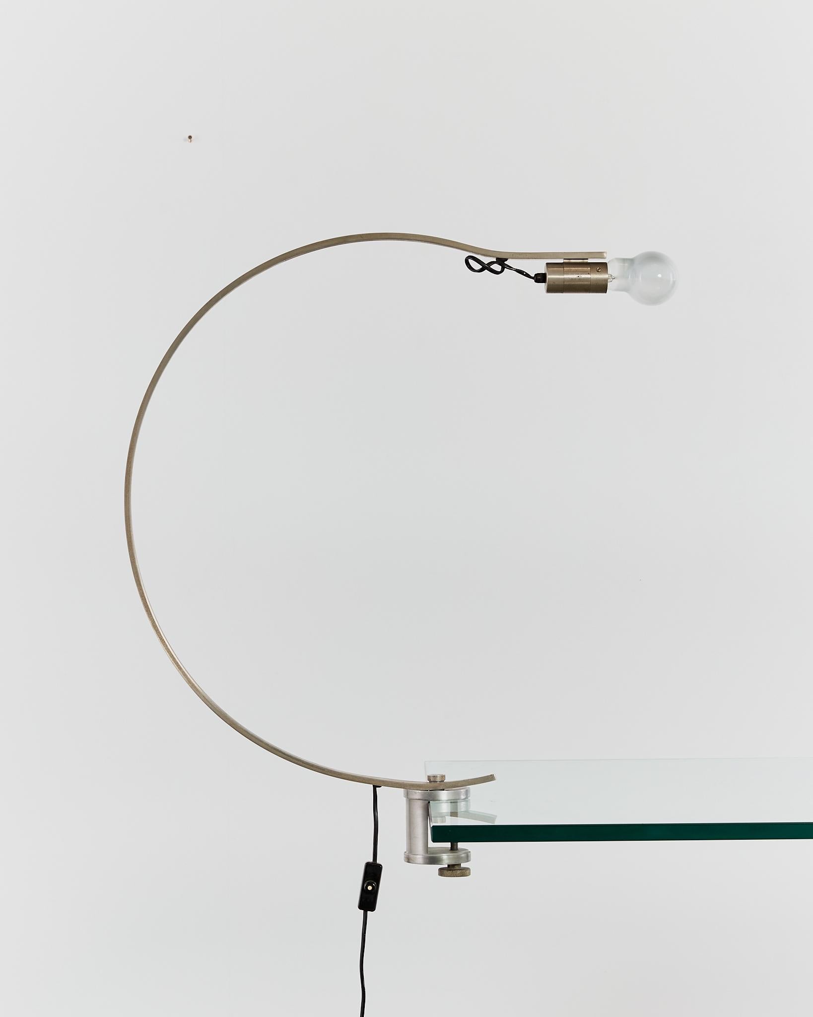 A simple curved steel form, the rare 'Witch' table lamp is attached via a (generous opening) mechanical clamp. It is able to be rotated left and right to suit.
Designer: Alonso Cagozzi

Manufacturer: Philips

Material: Steel

Period: