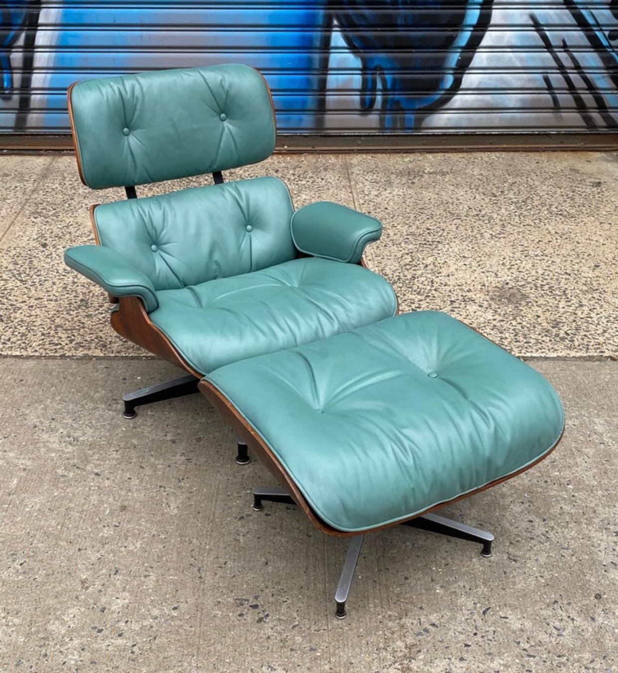 Incredibly vibrant edition of the Classic Eames lounge chair and ottoman. Signed and guaranteed authentic. Blue green leather is not a color we have come across before. Vintage chair with original exotic wood shell exterior and cast aluminum bases