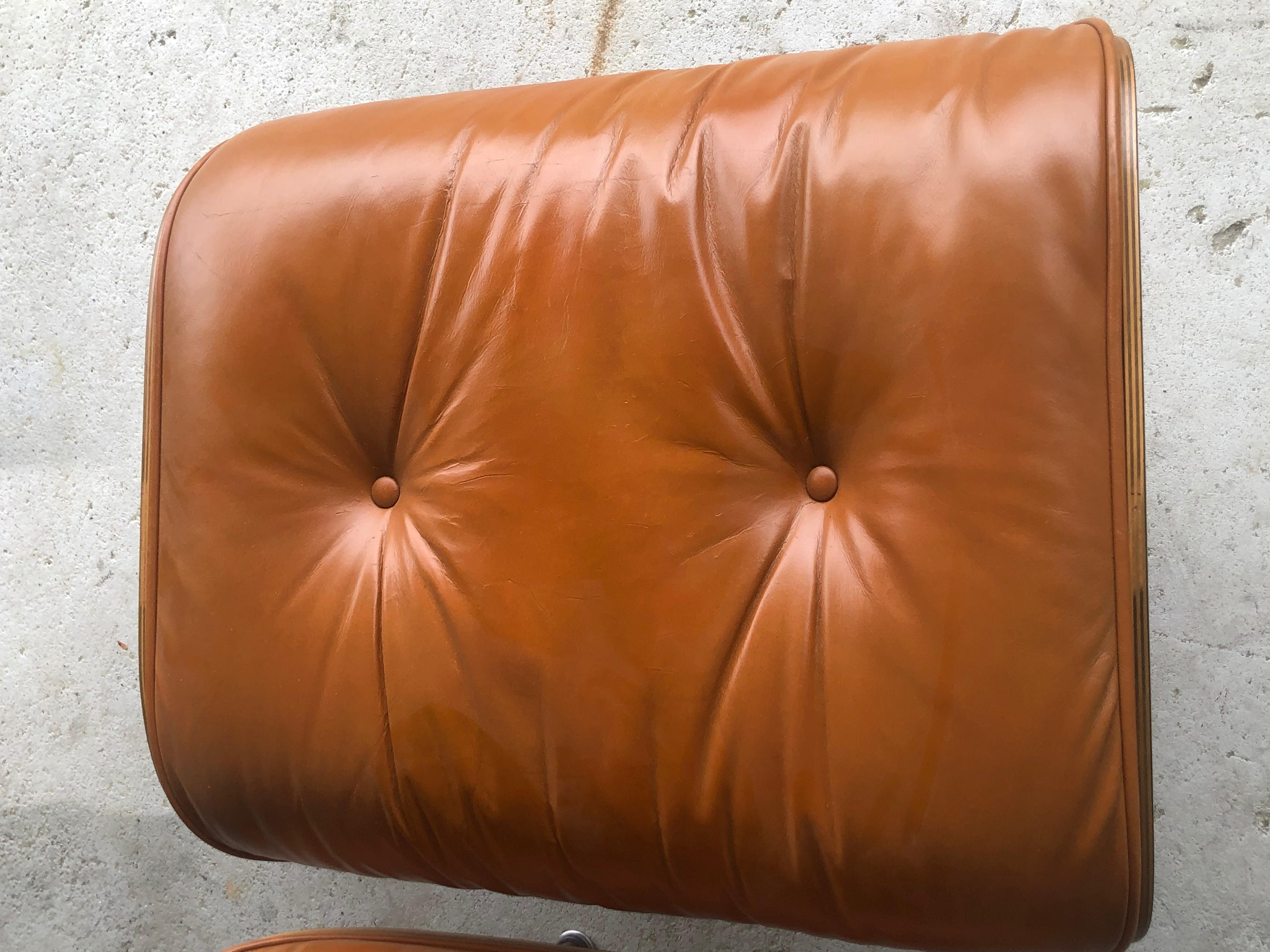 Beautiful Eames lounge chair and ottoman in rosewood and burnt orange leather. Vintage chair and ottoman with new leather. Signed and guaranteed authentic Herman Miller chair and ottoman from the 1960s/1970s. Leather cushions are custom made and