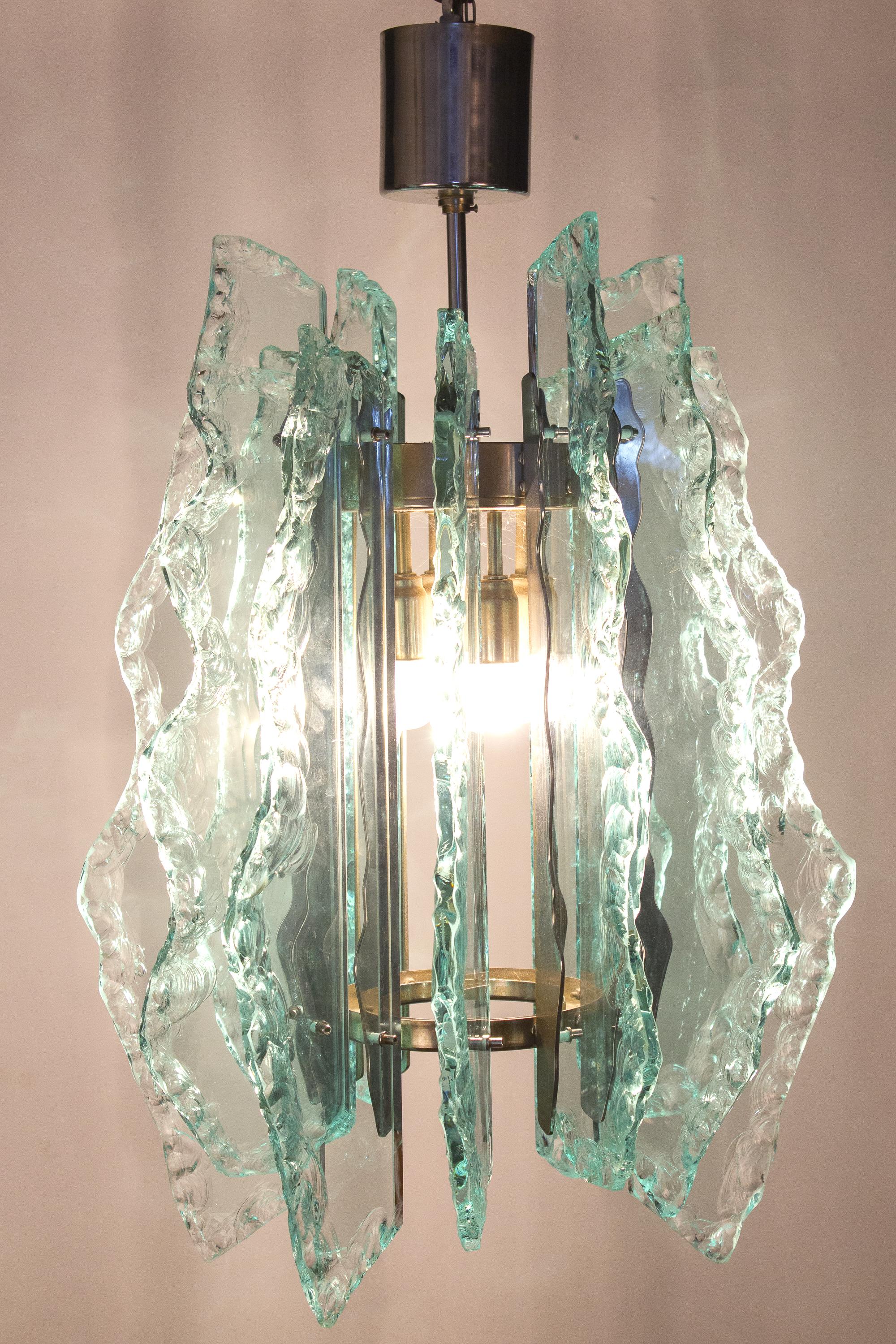 Amazing  Mid - Century  Fontana Arte  chandelier. Chrome frame with precious green colored Hammered cut-glass.
 Available an other chandelier with gold frame. 
Lighting: takes six small Edison E14 base screw bulbs.
Wattage: we recommend up to 40w