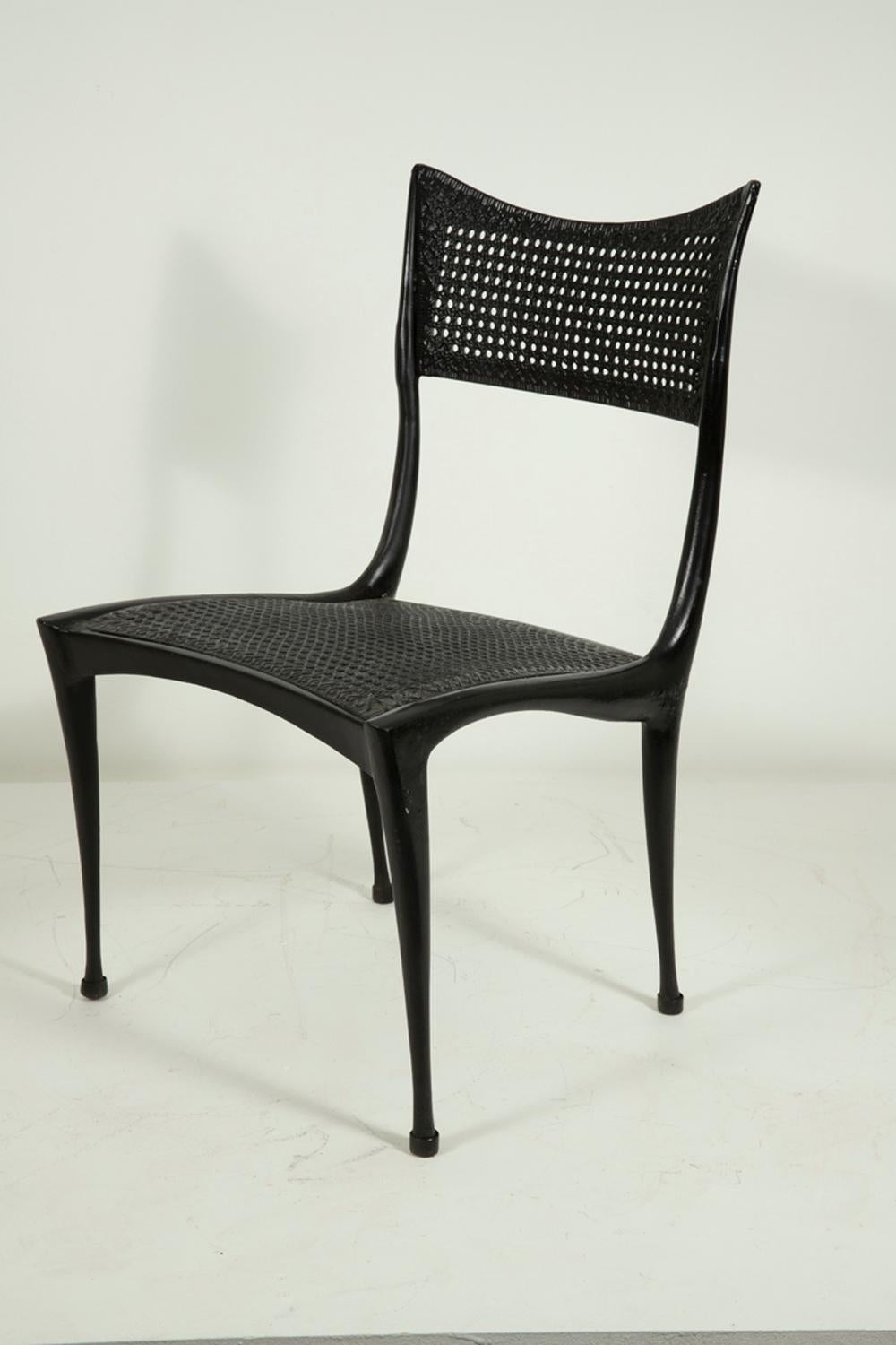A rare single chair in executed in cast aluminum, with a black enamel finish.