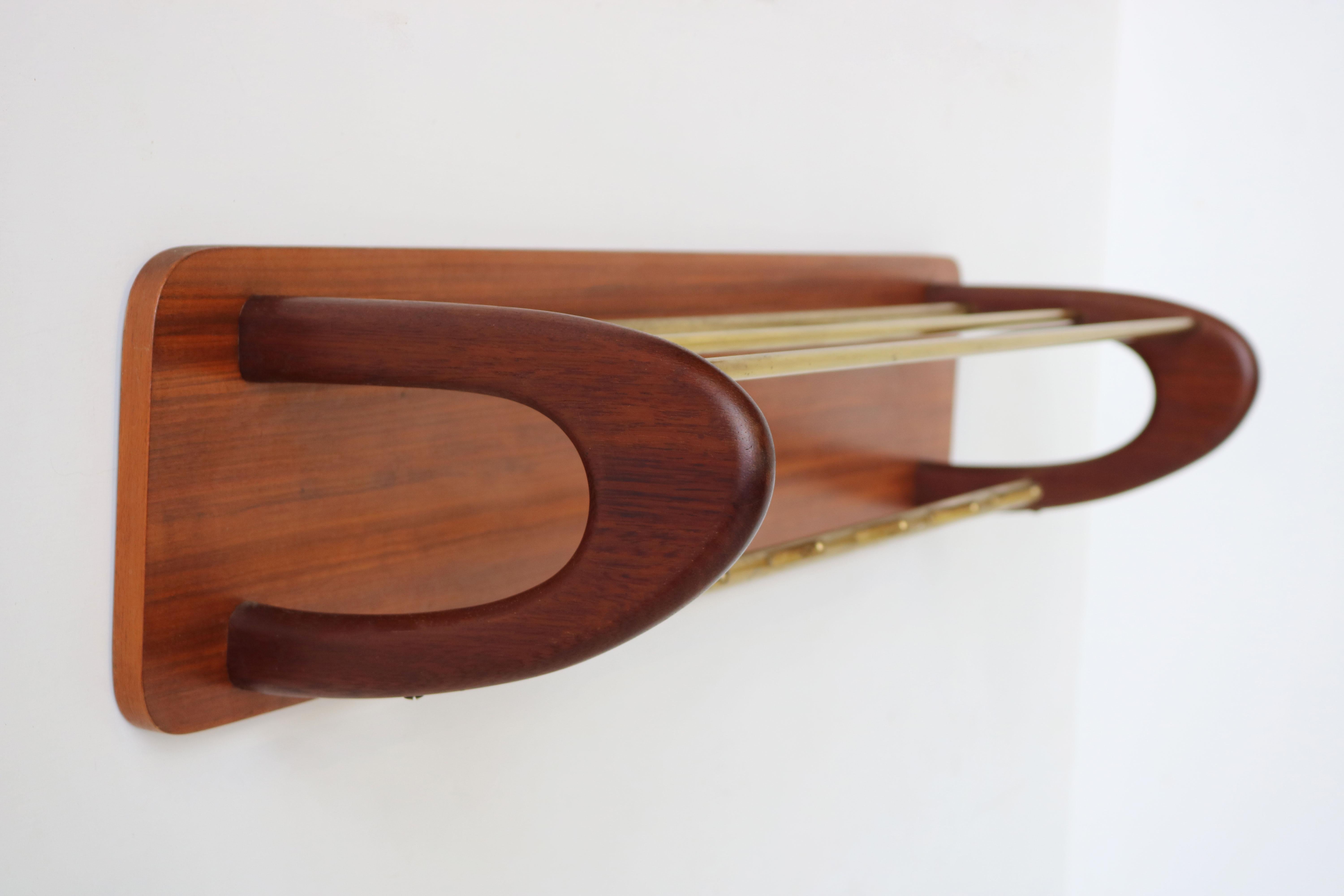 Stylish & timeless! This Danish Design boomerang coat rack in teak & brass from the 1960s 
The coat rack is made out of organic sculpted solid teak combined with brass rods & a teak back. 
Marvelous subtle design , a real statement piece for your