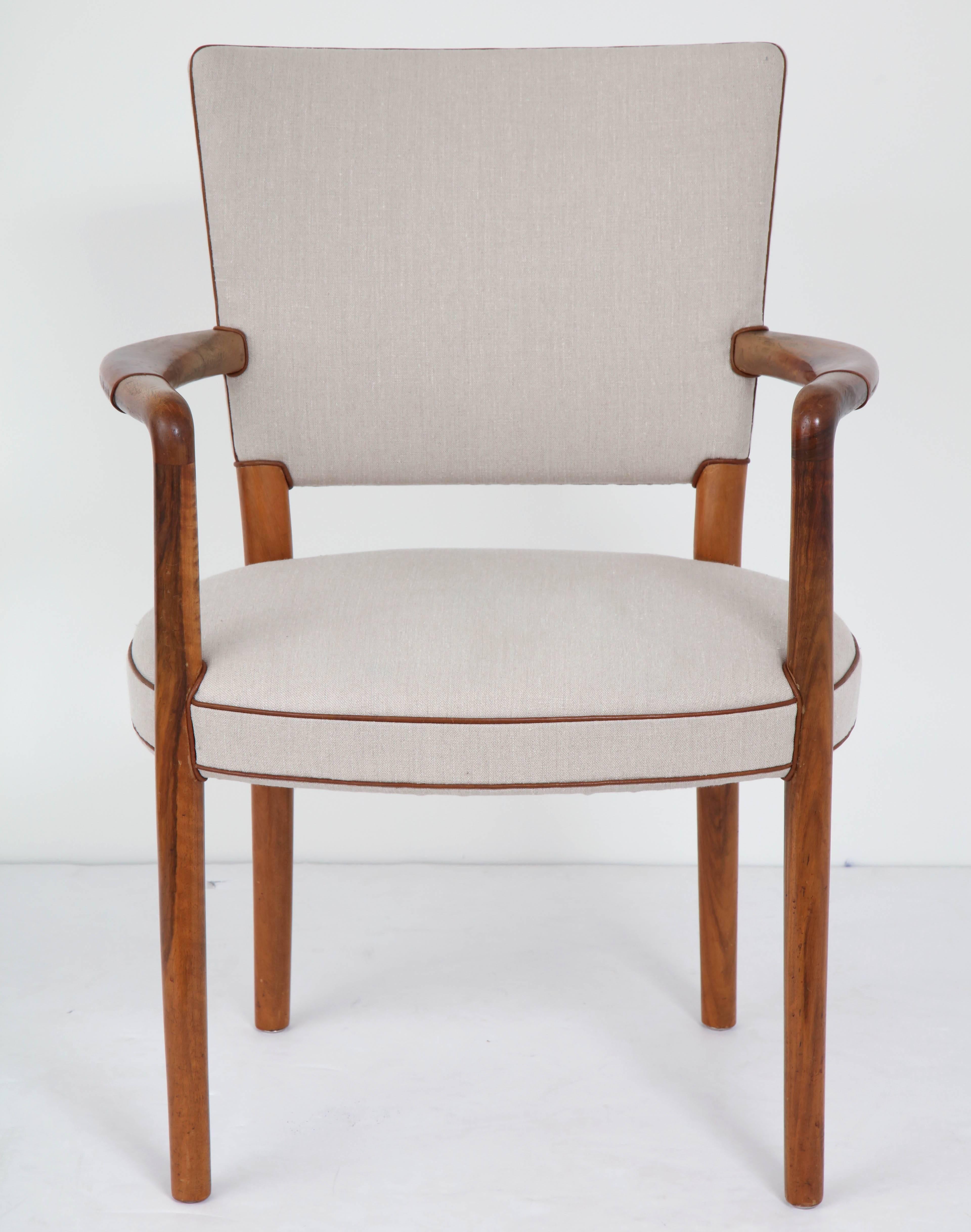 Rare Danish design chair by Flemming Lassen and Arne Jacobsen, circa 1950s, fruitwood and patinated leather with fine linen upholstery. Retaining original partially padded leather armrests. New linen. Superb patina and re-upholstered to closely