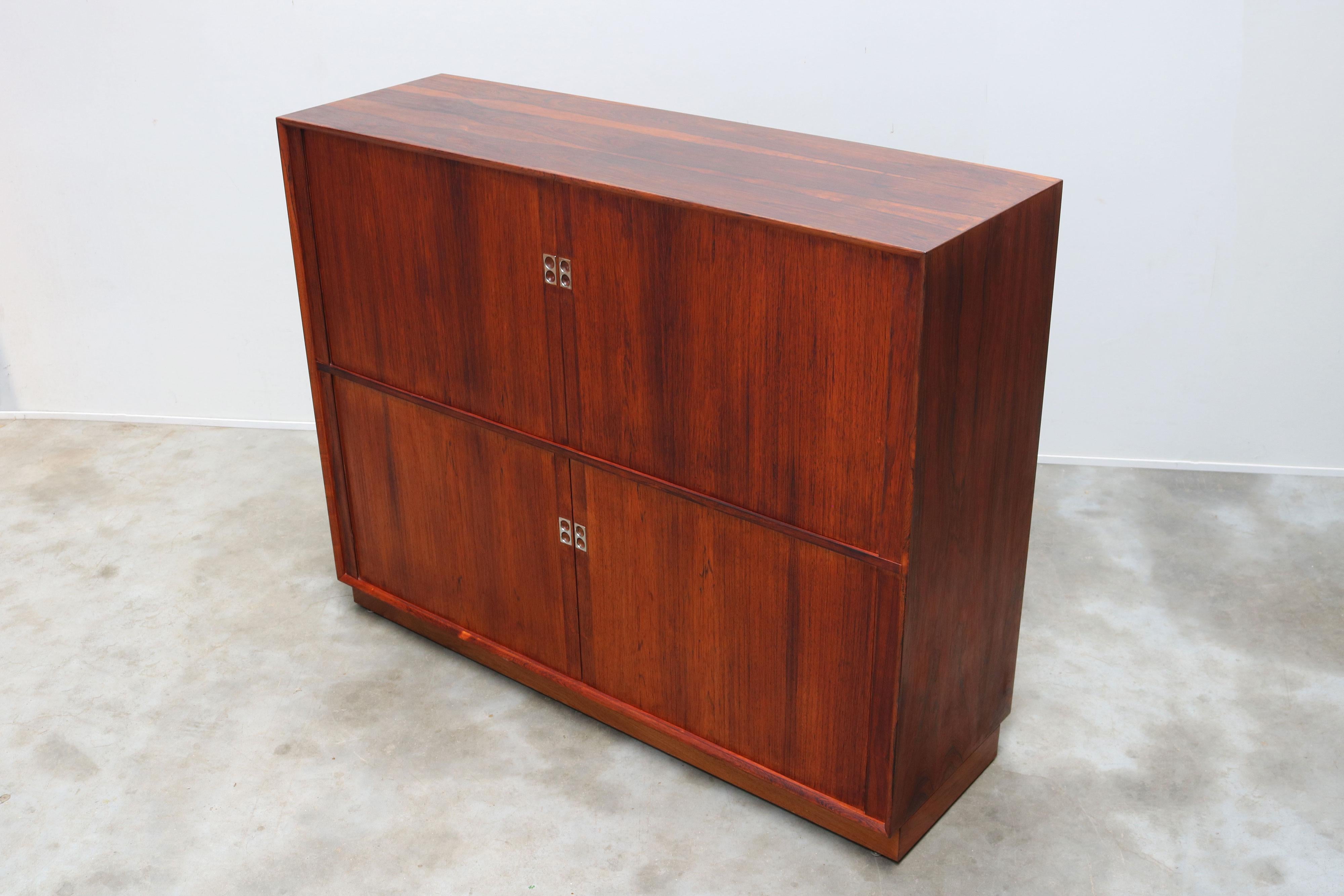 Prova l'epitome del lusso moderno di metà secolo con la credenza in palissandro con ante a tamburo di Arne Vodder, realizzata nel 1958 per Sibast Furniture. Questo squisito pezzo non è semplicemente una credenza, ma è una testimonianza di un design