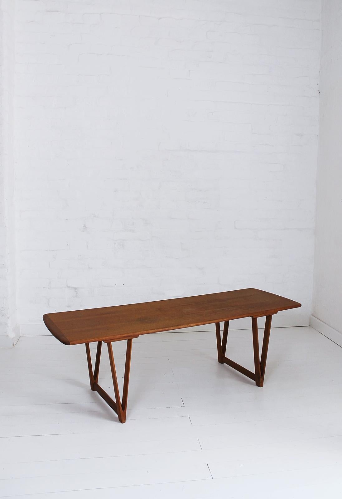 Stylish and rare Danish Mid-Century Modern teak table on V-shaped legs. Designed by Andreas Hansen and made by Arrebo Mobler in the 1960s. Is in good condition. The surface of the tabletop is slightly damaged as shown in the pictures. Label to