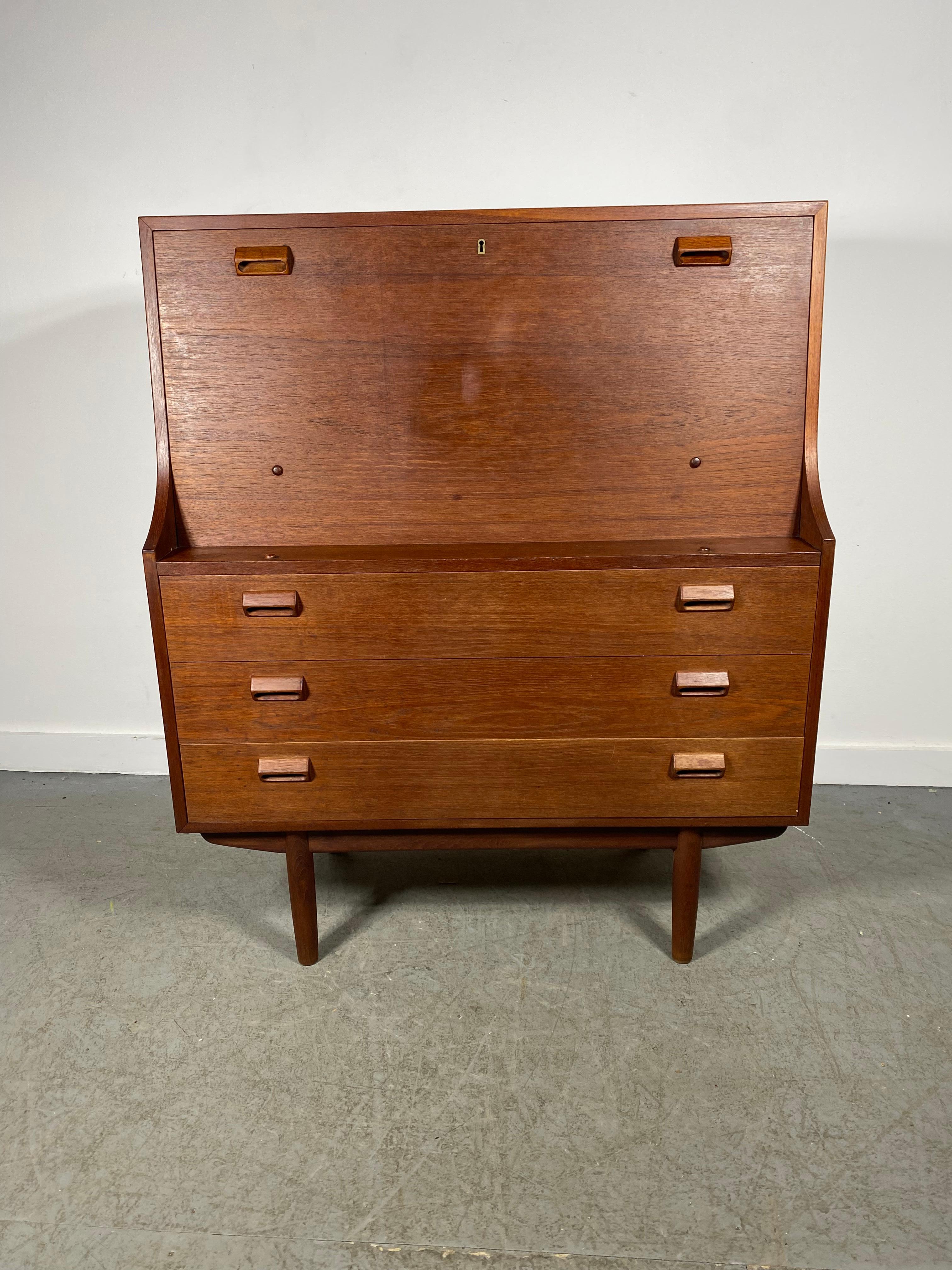 Mid century Borge Morgensen teak secretary desk is part desk, part storage. Bottom part has three drawers. Top leaf drops down into a writing surface. Multifunctional and elegant, this desk can serve as both a desk and an entryway piece. Great